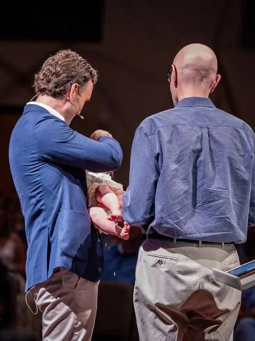 Lead Pastor John Bourgeois and assistant baptizing a child during worship service at West End Community Church in Nashville, TN.