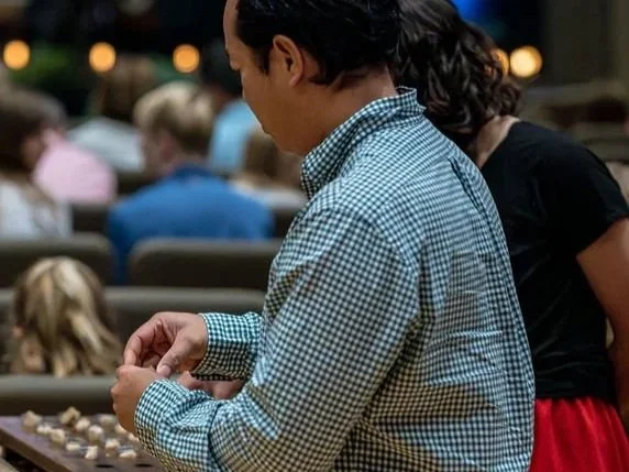 A man in a checkered shirt receiving the Lord's Supper during worship service at West End Community Church in Nashville, TN.