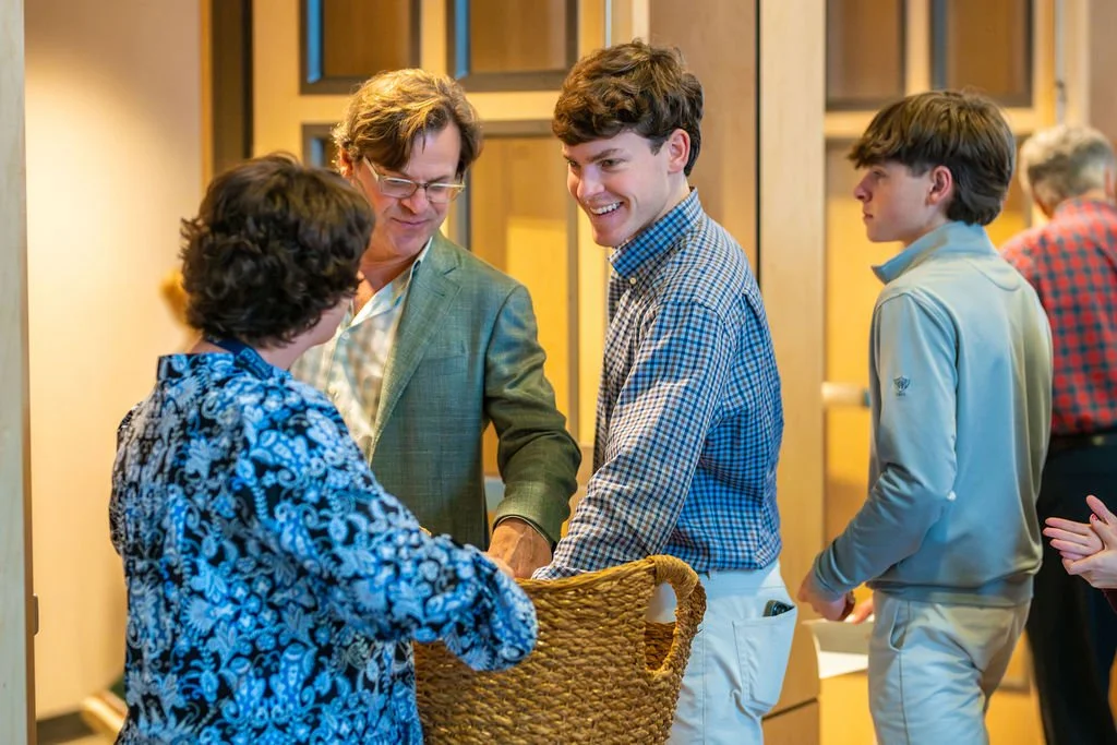 Middle school aged students take a bulletin from a church volunteer on their way into worship service on Sunday at West End Community Church in Nashville, TN