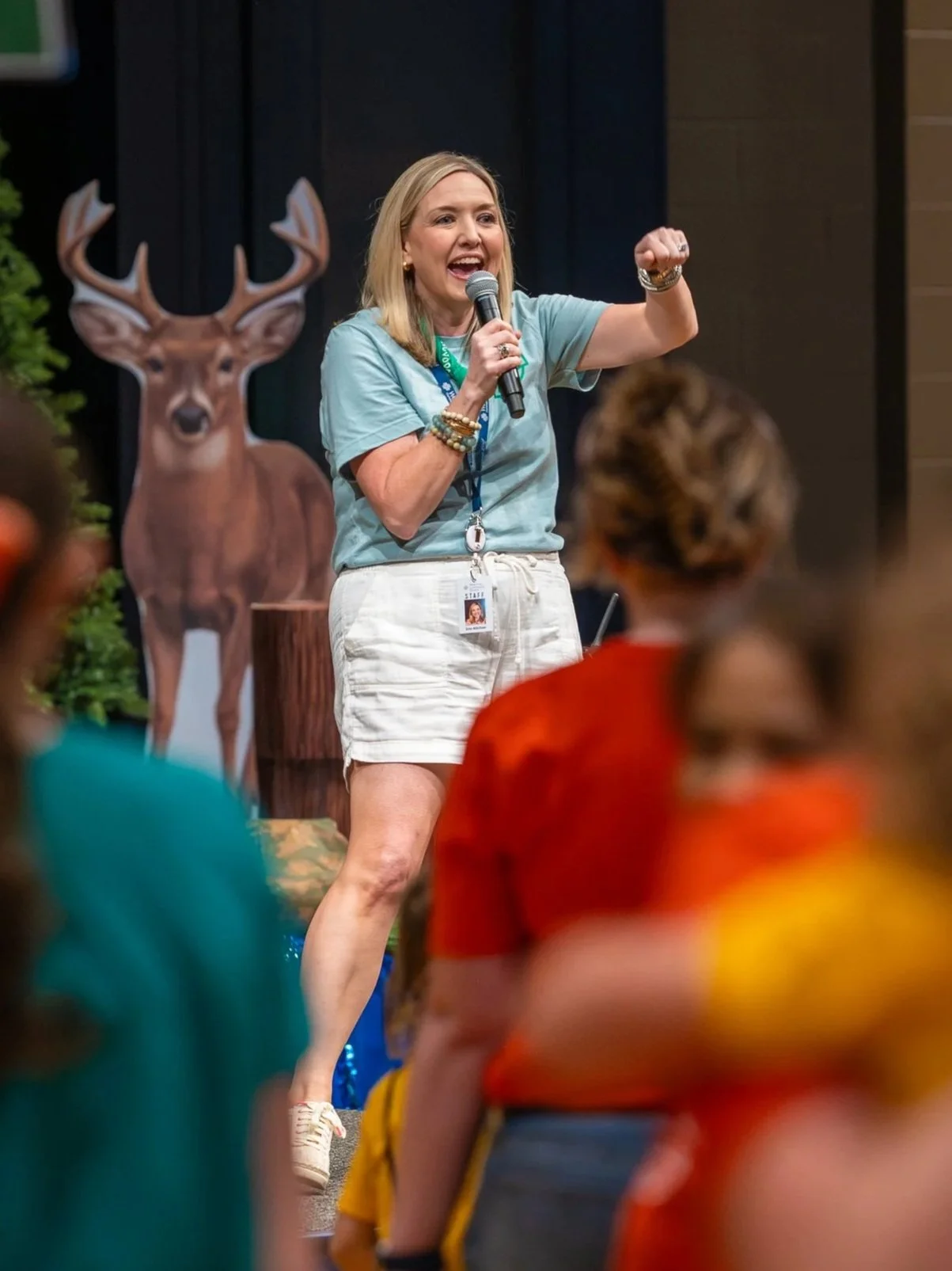 Director of West End Kids, Erin Kitchin, leading Vacation Bible School, surrounded by seated children.