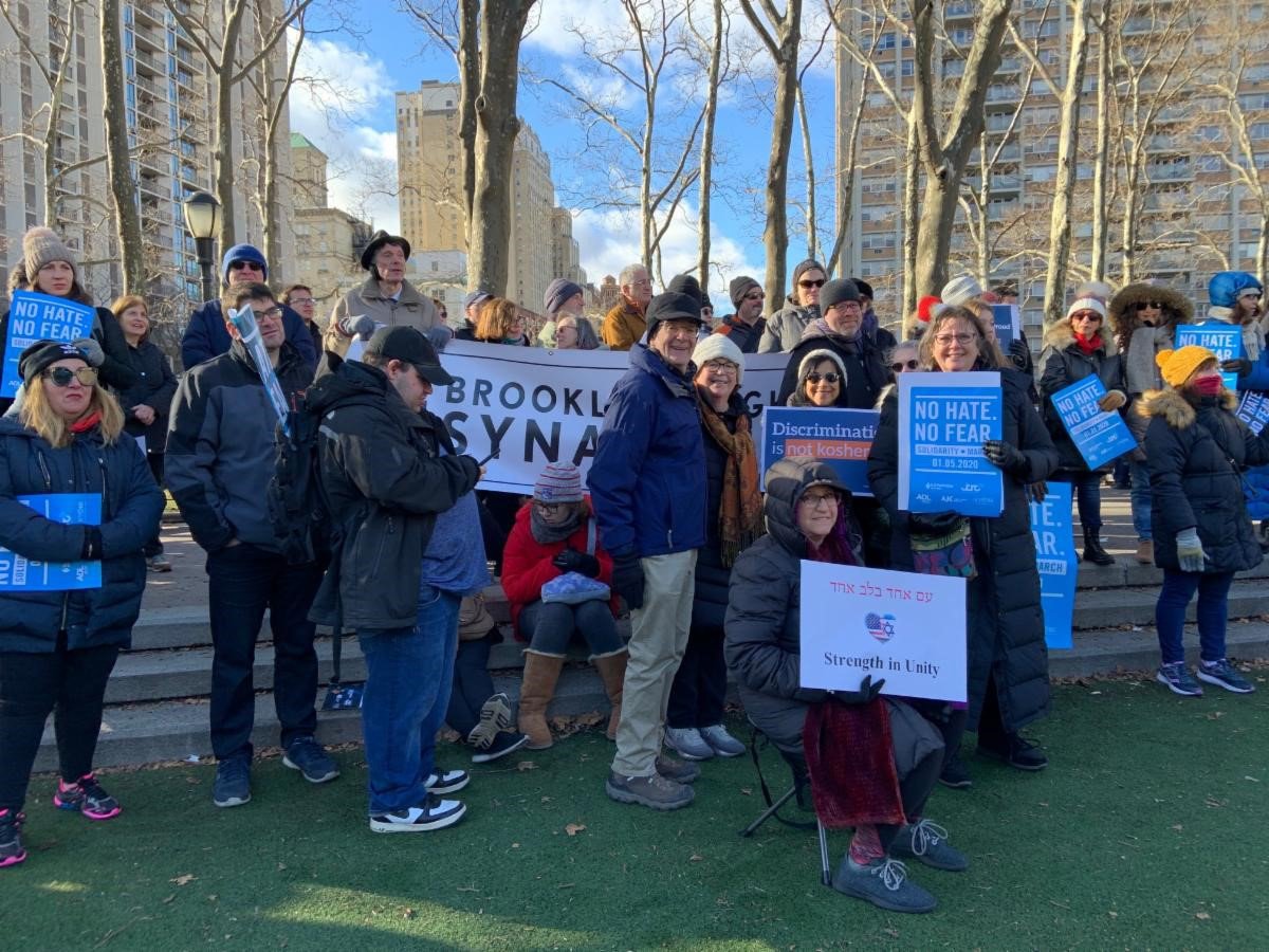 members of the synagogue gather with signs and banners during a solidarity march in January of 2020