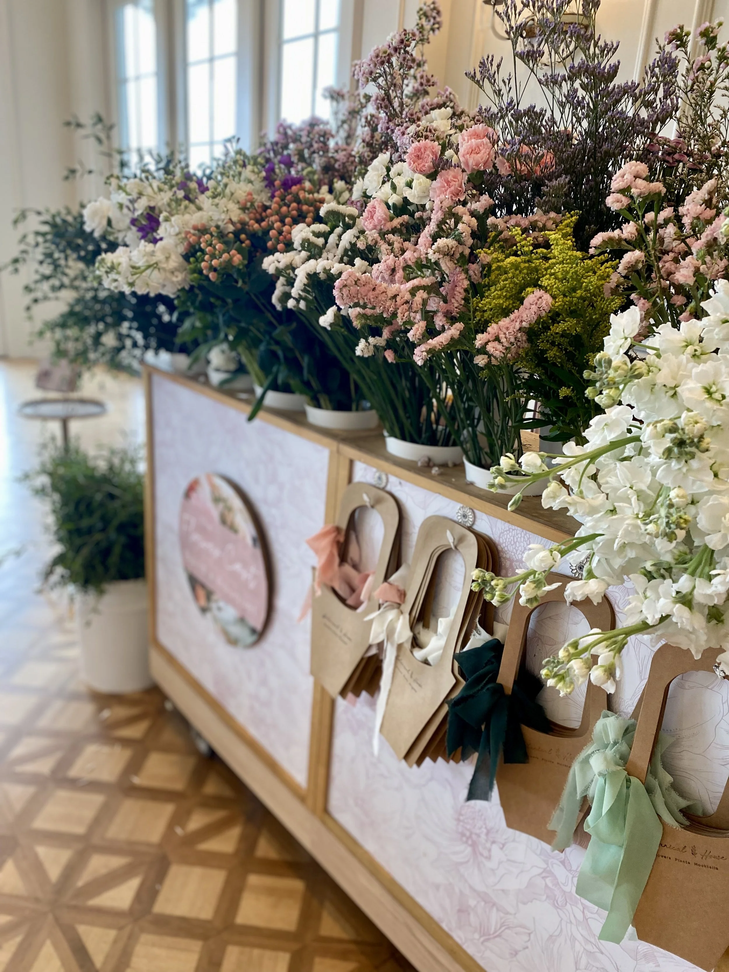 A flower cart full of fresh colorful flowers and bouquet carriers