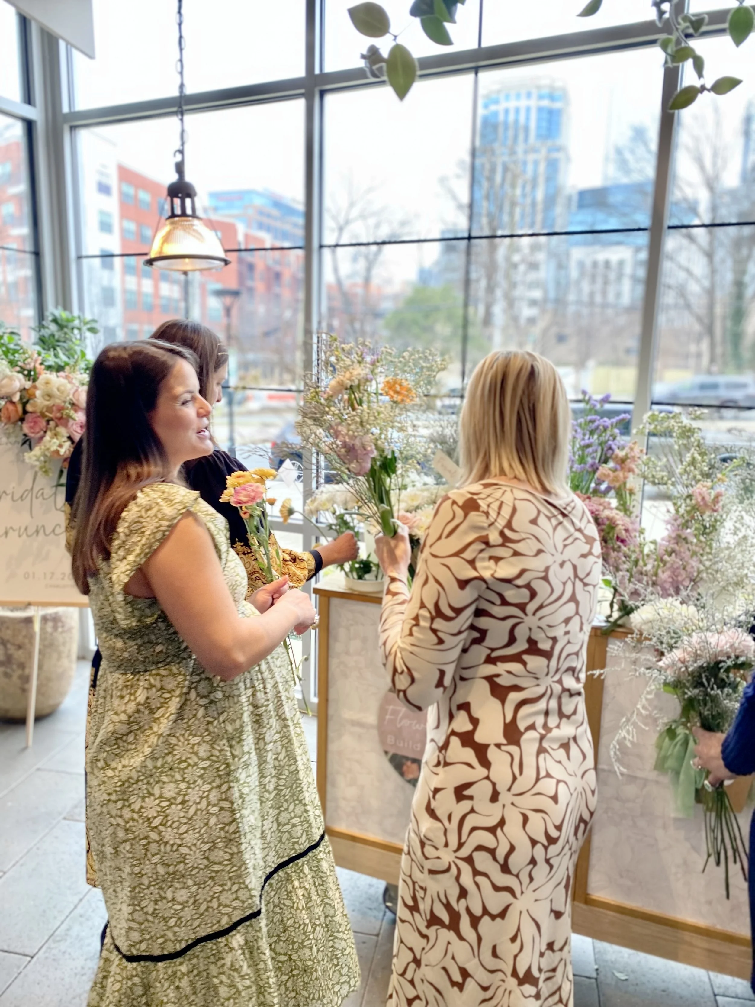 Three women making bouquets at a flower bouquet cart