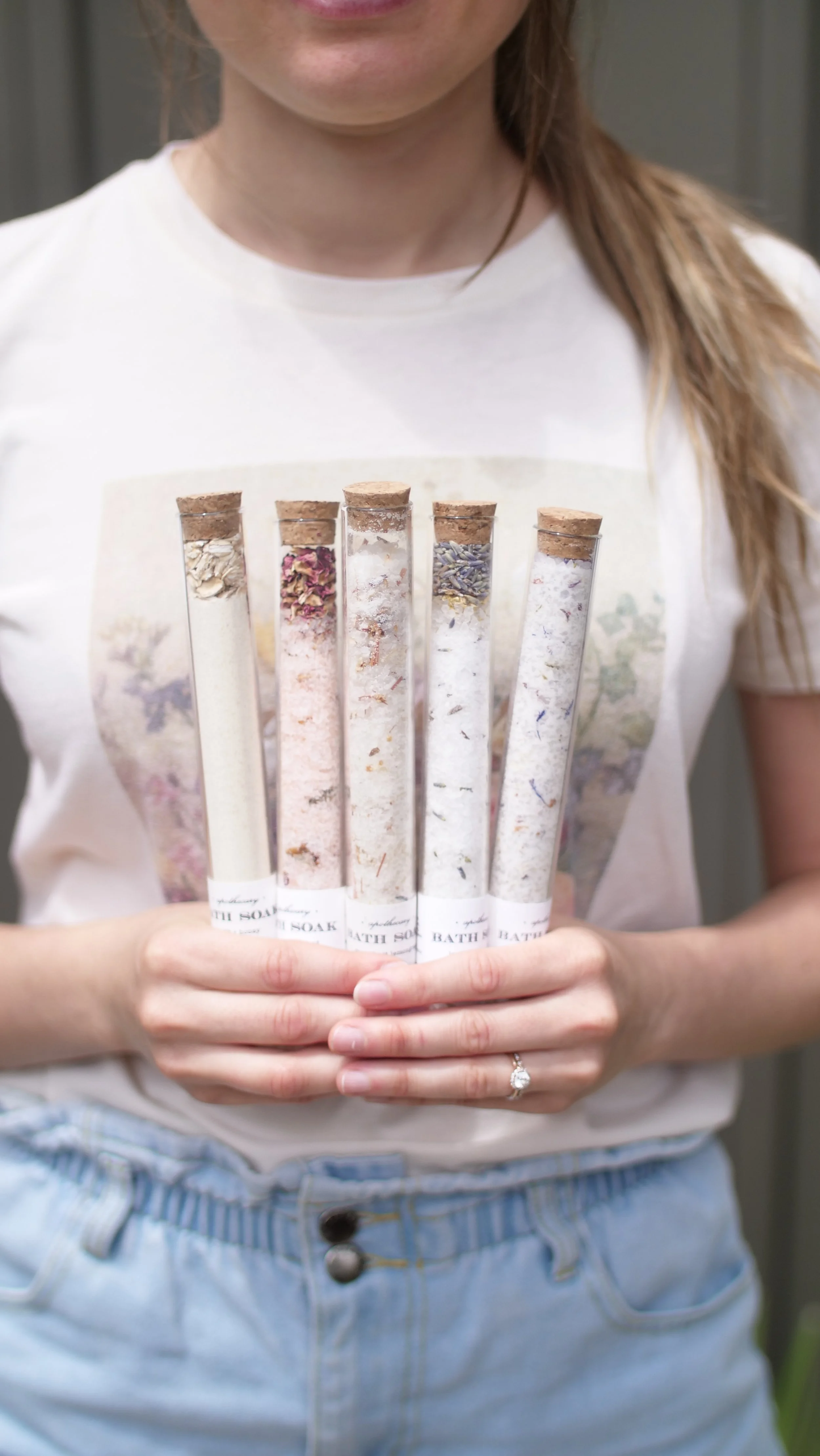 Two hands holding floral bath salts