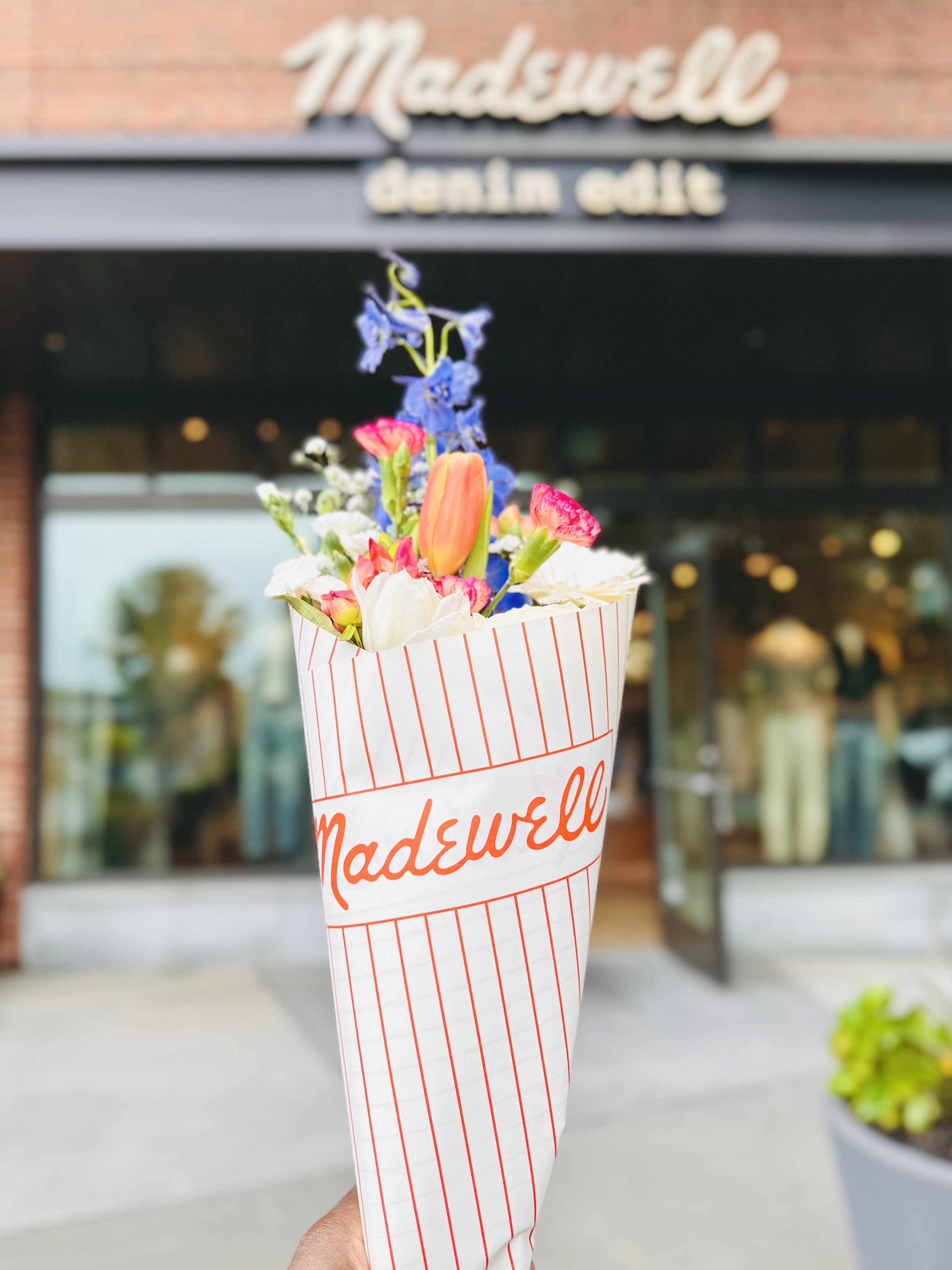A bouquet of flowers in front of a Madewell store in Charlotte, NC