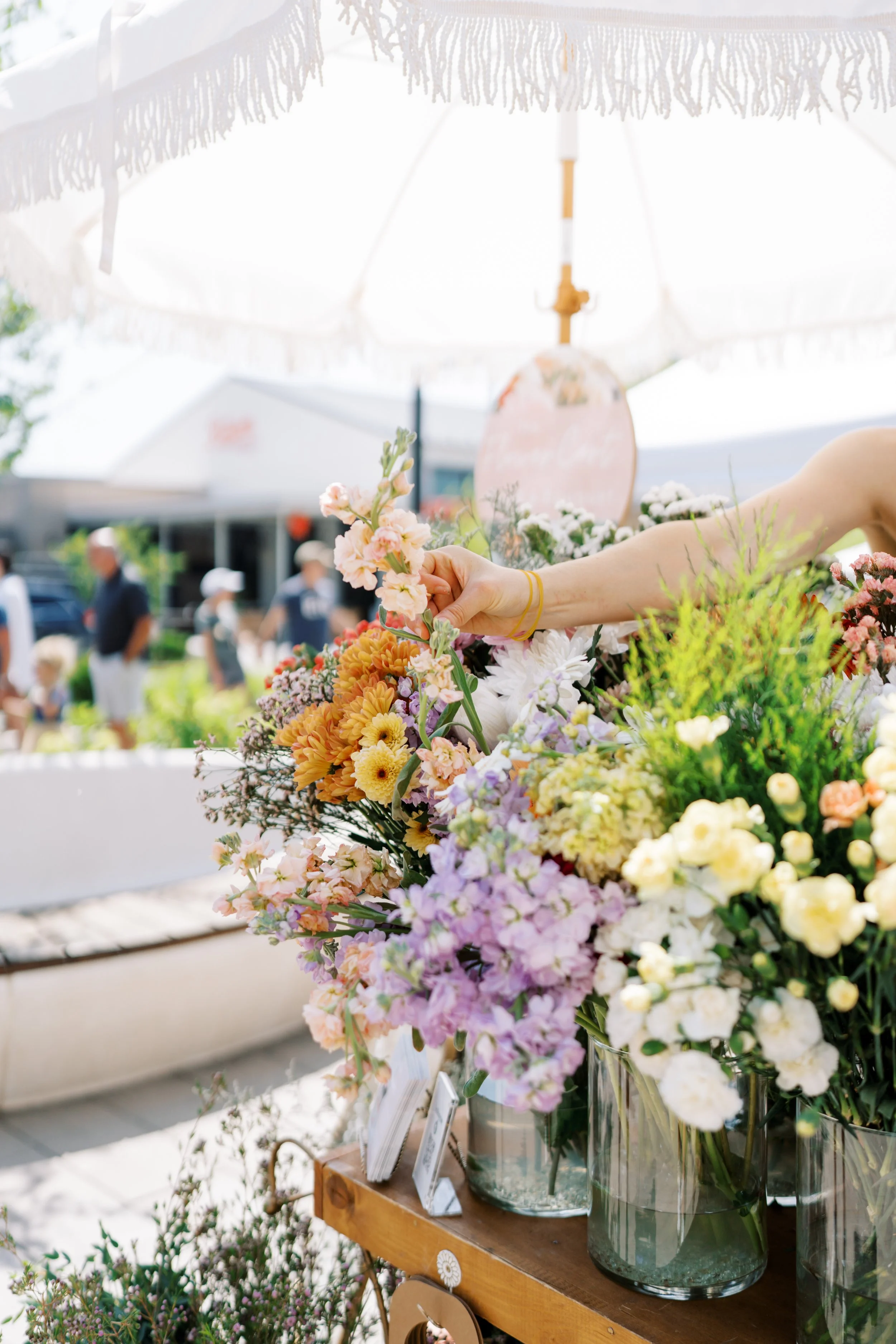 Someone picking a flower from a bouquet bar