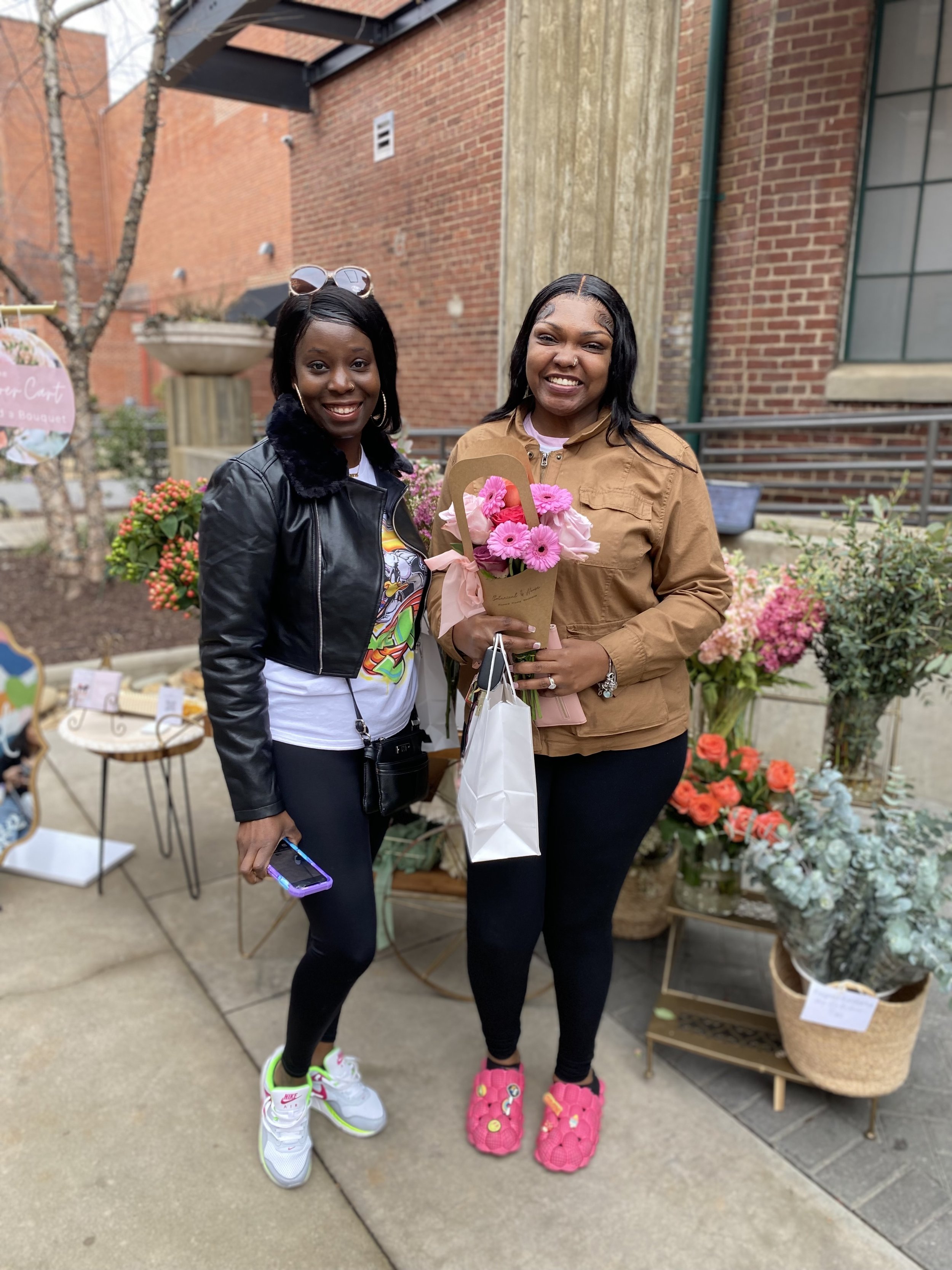Two women holding bouquets of flowers