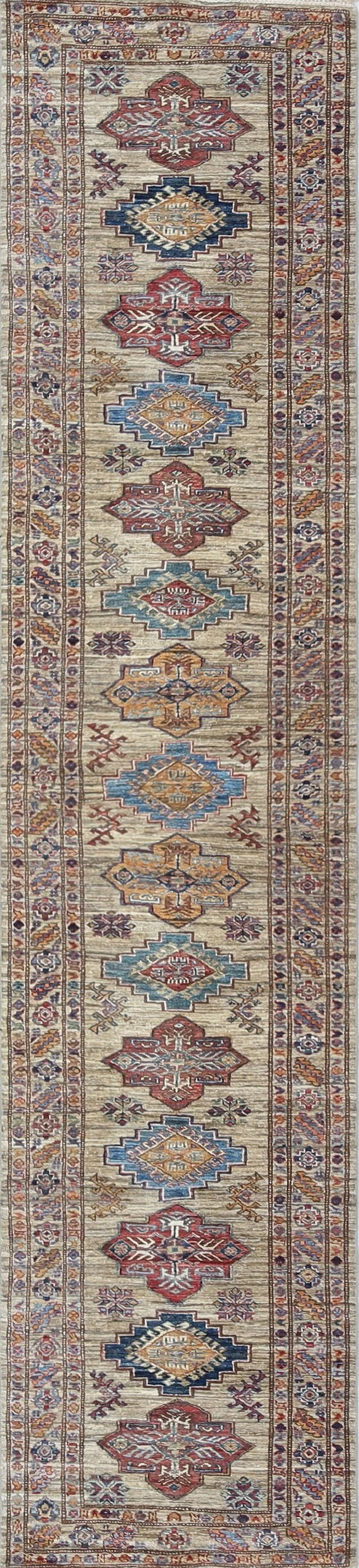 A hand-knotted Super Kazak wool rug runner approximately 14 feet long in a tobacco colour combination.