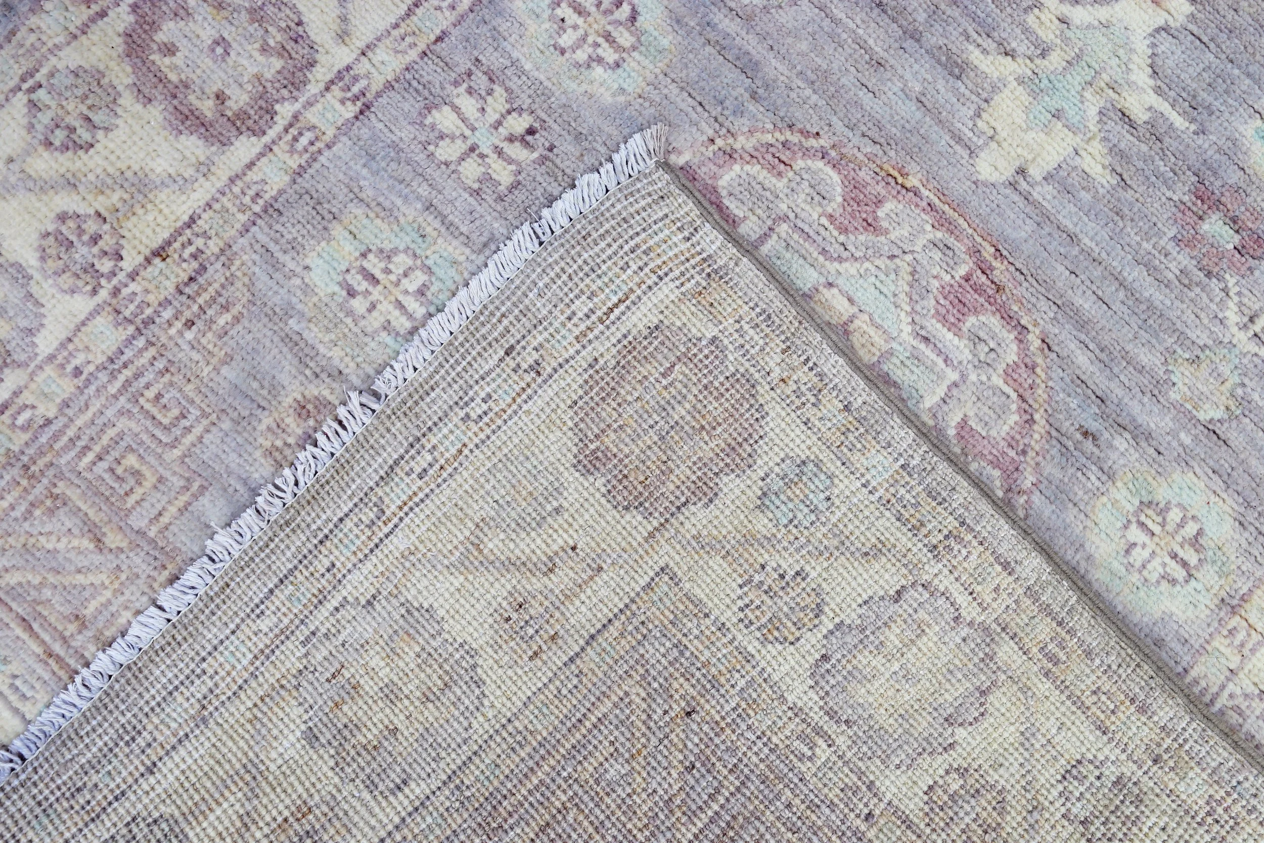 A hand-knotted Khotan neutral wool rug runner 14 feet long.
