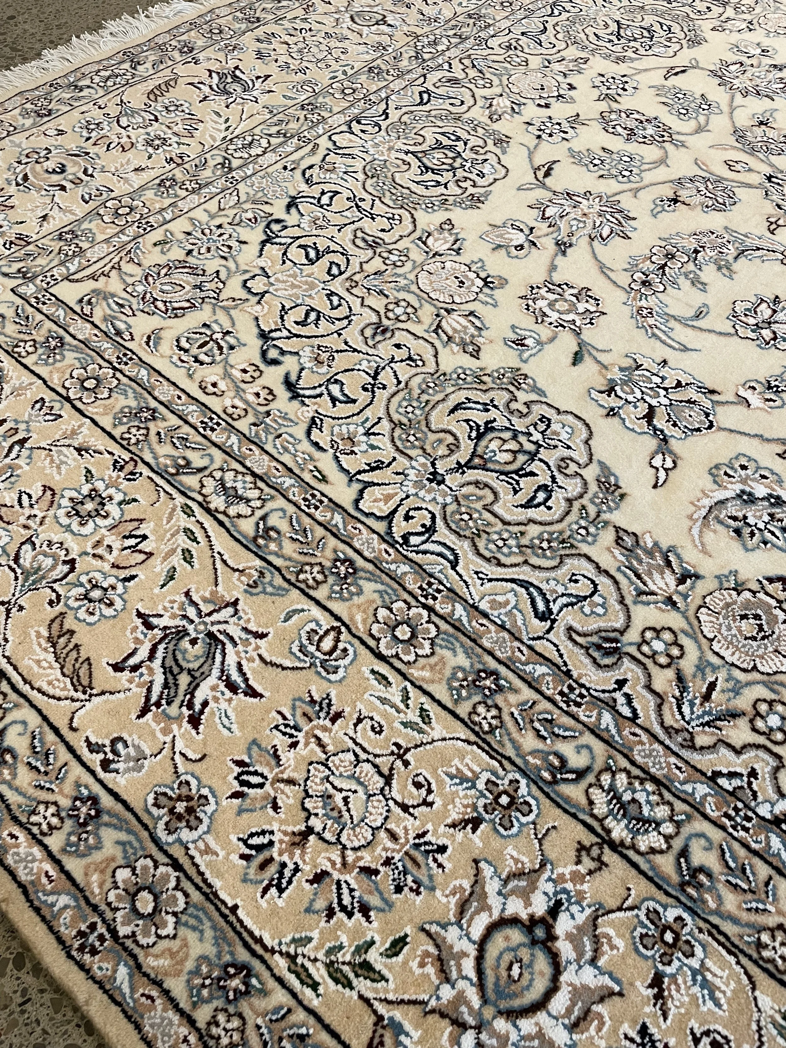 A hand-knotted wool & silk Naeen rug in a cream and blue colour combination.