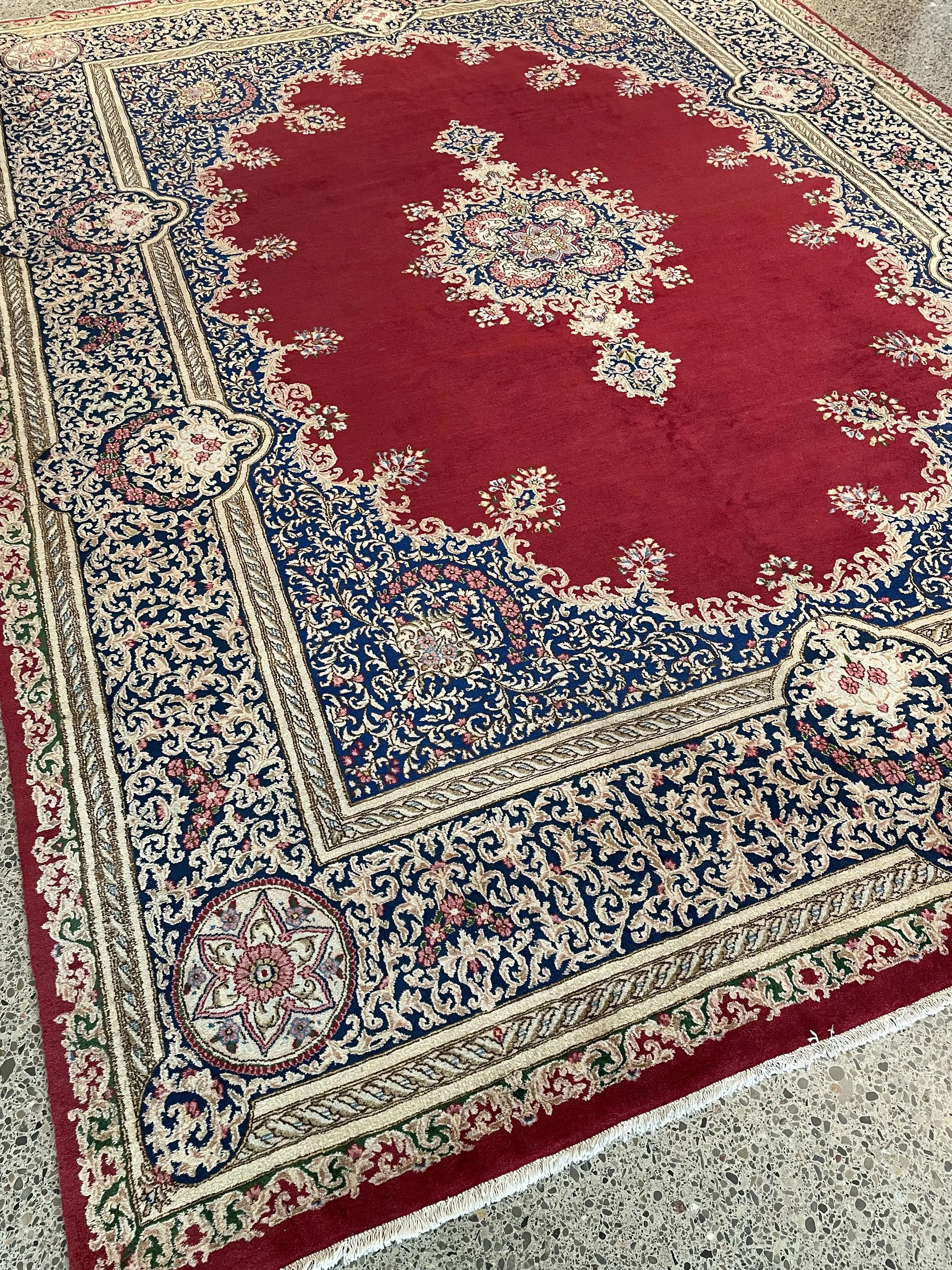 A hand-knotted Kerman 10x13 semi-antique Persian rug made with wool.