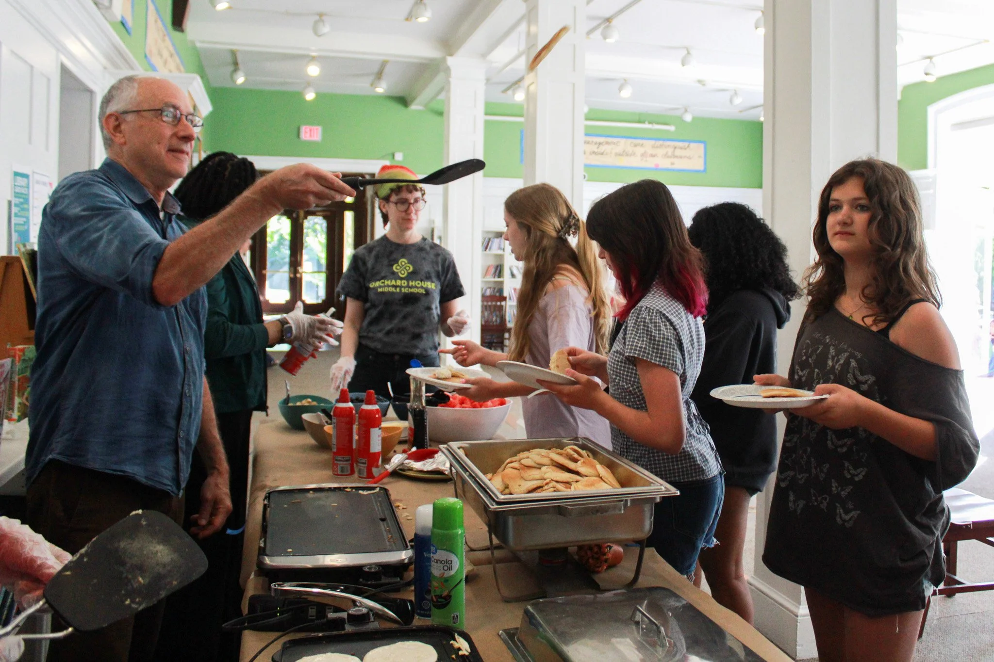 The school year isn't over until each student has had the chance to catch (or fumble) pancakes on the last day, expertly flipped by Ms. Nott and Mr. Hollander.