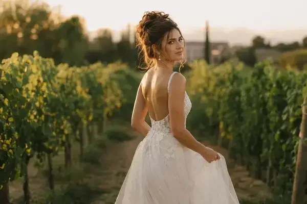 Bride wearing a high tousled wedding updo at an outdoor garden venue