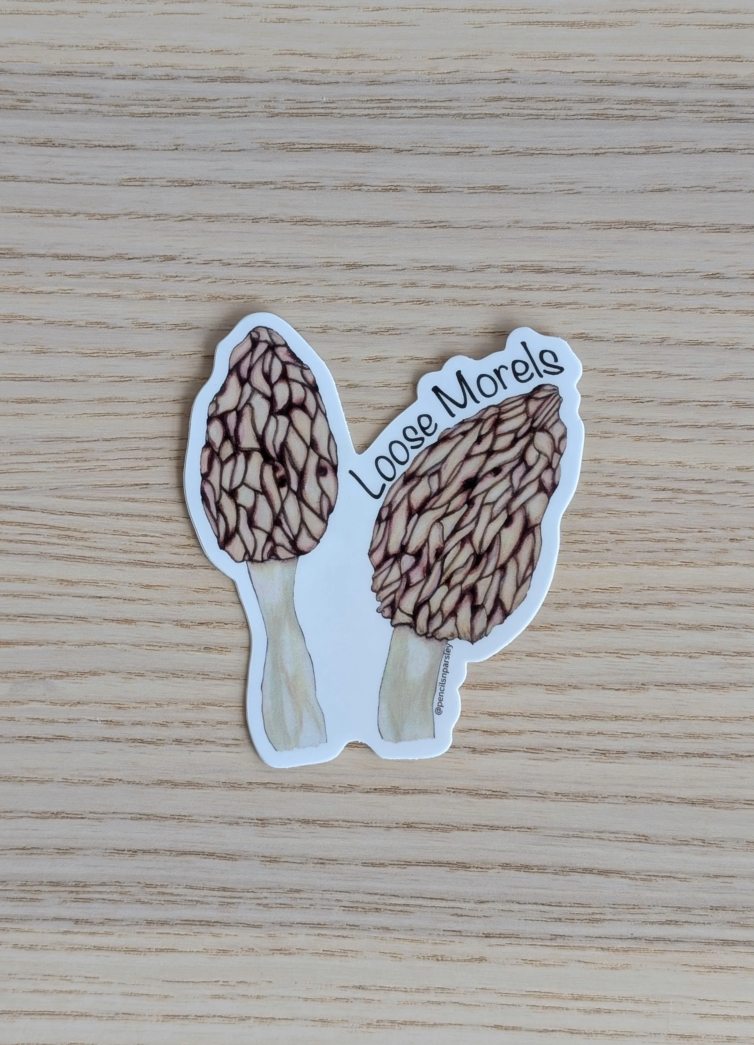 Vinyl sticker of two morel mushrooms and the text "Loose Morels" on a table.