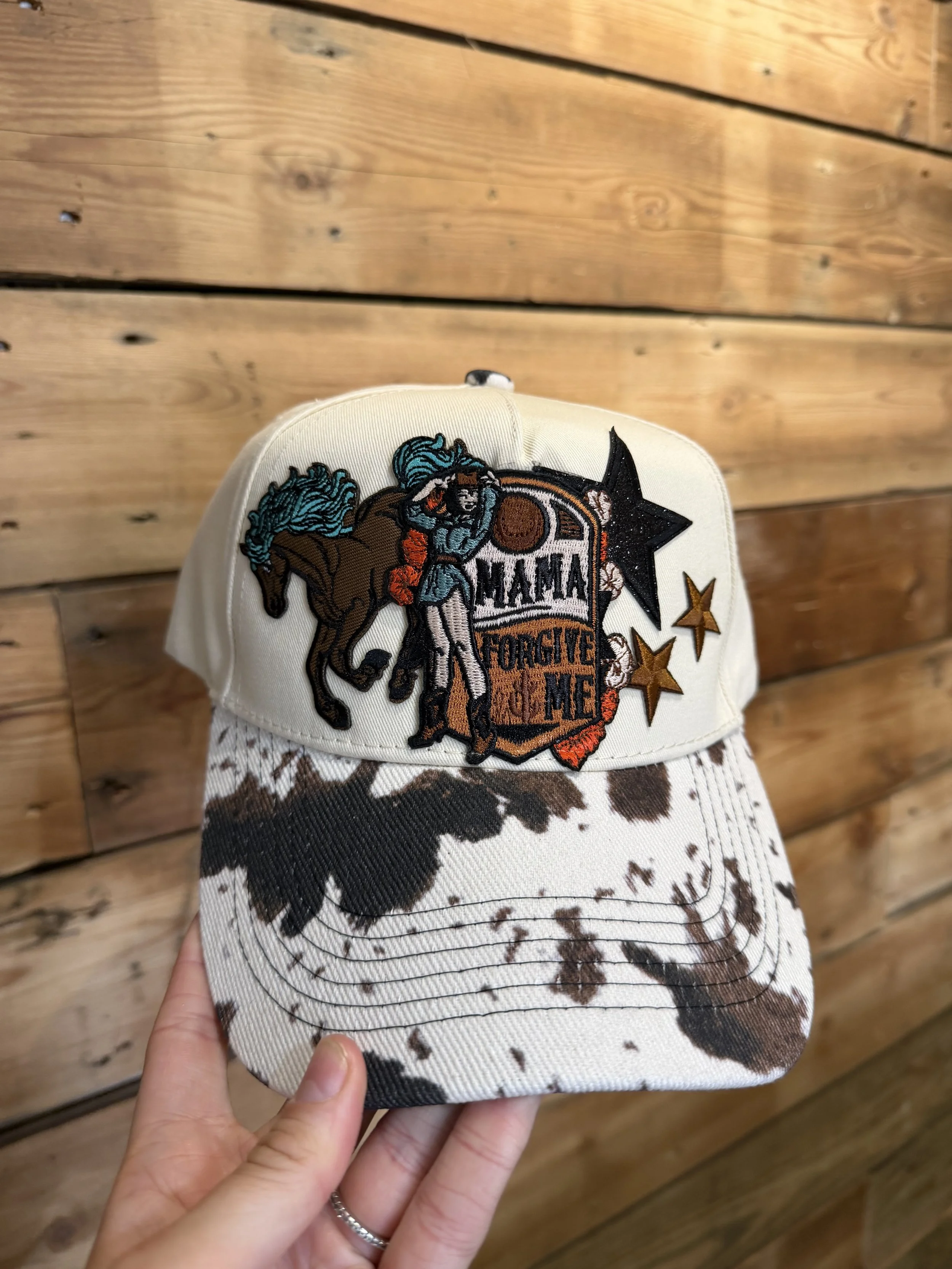 A white baseball cap with a patch featuring a woman riding a horse, with a black star and the words 'DONT FORGET ME.'