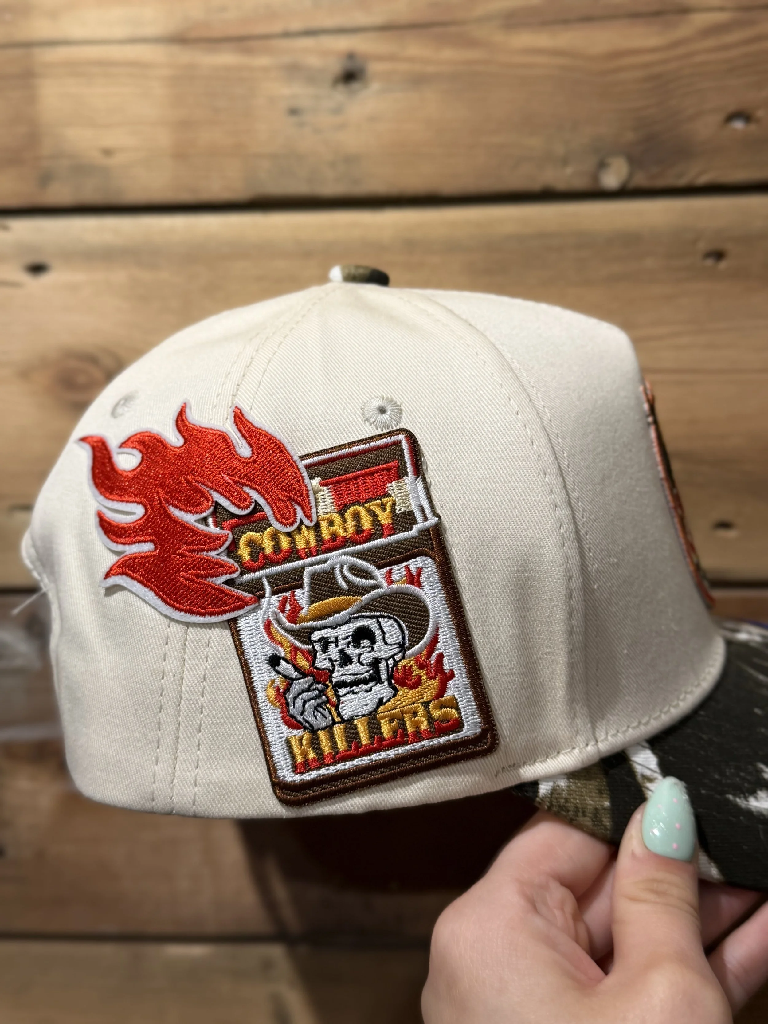 A beige baseball cap featuring an embroidered logo of a red flame and a skeleton holding a torch with the text 'Fire Boyz' on the front.