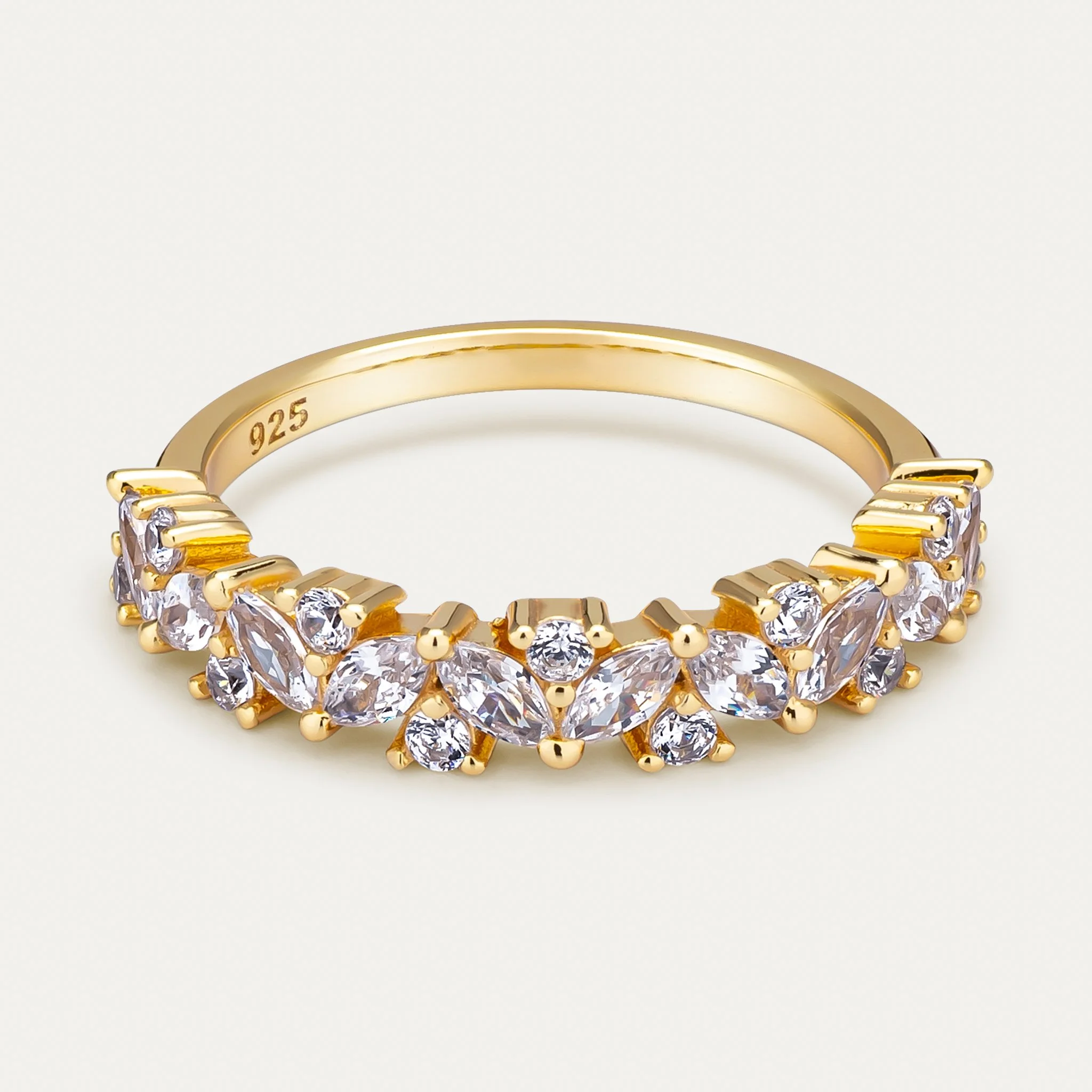 Gold ring with clear gemstones in a decorative pattern.