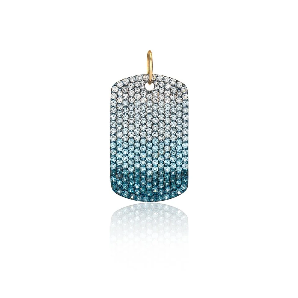 A jewelry pendant decorated with small diamonds in a gradient from white to dark blue, hanging from a gold loop.