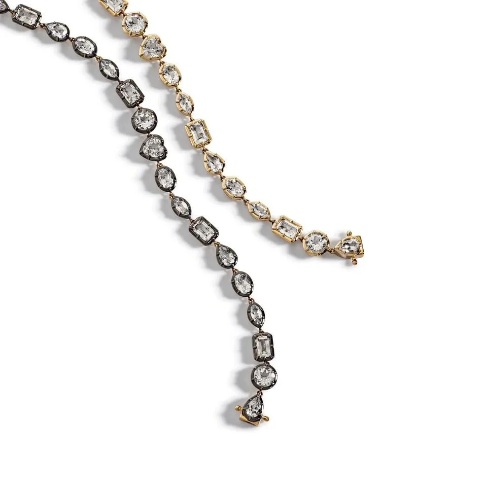 Two elegant diamond necklaces, one with blackened metal and the other with gold, featuring a series of various cut diamonds.