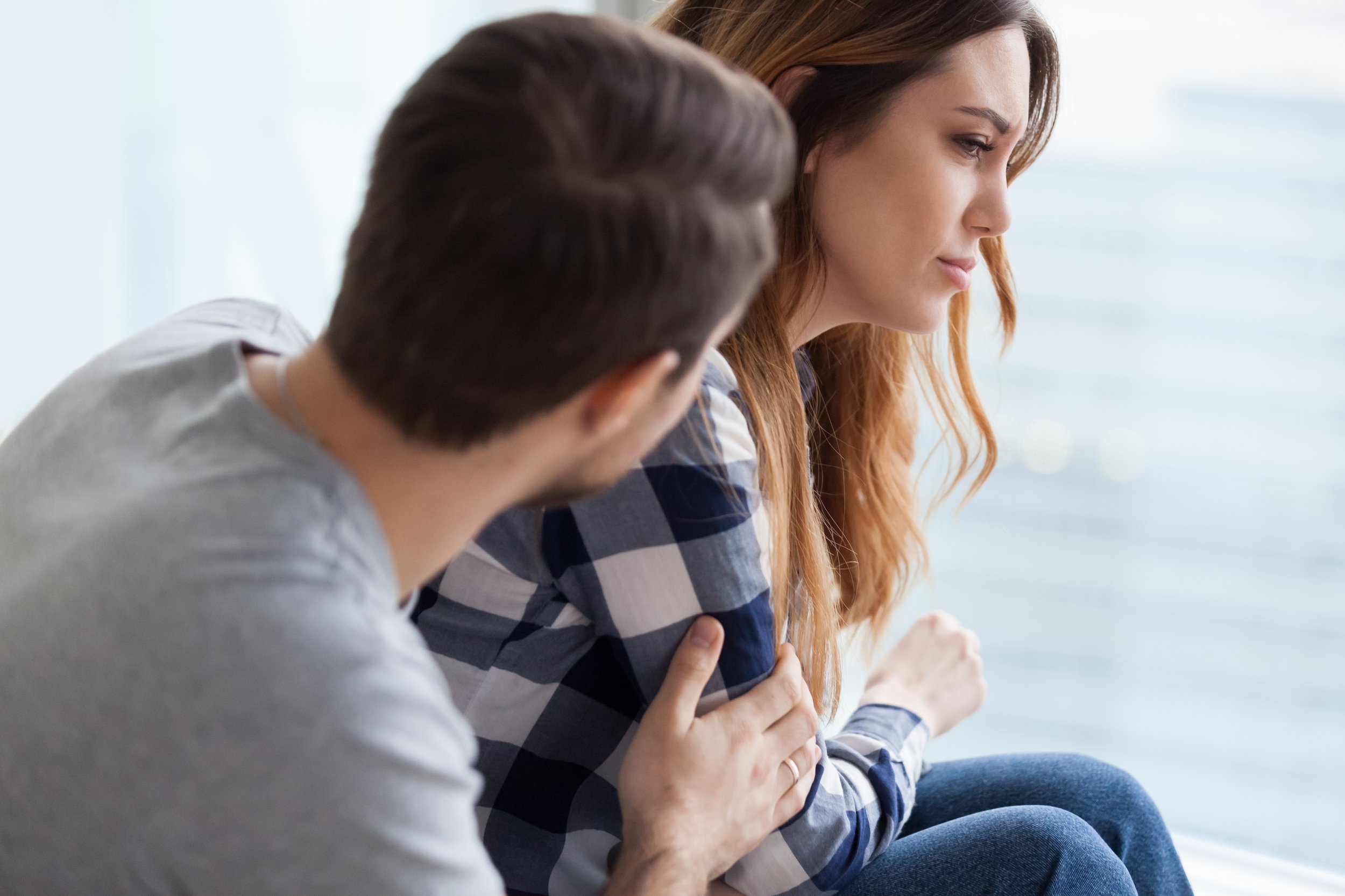 man comforting partner suffering from postnatal depression