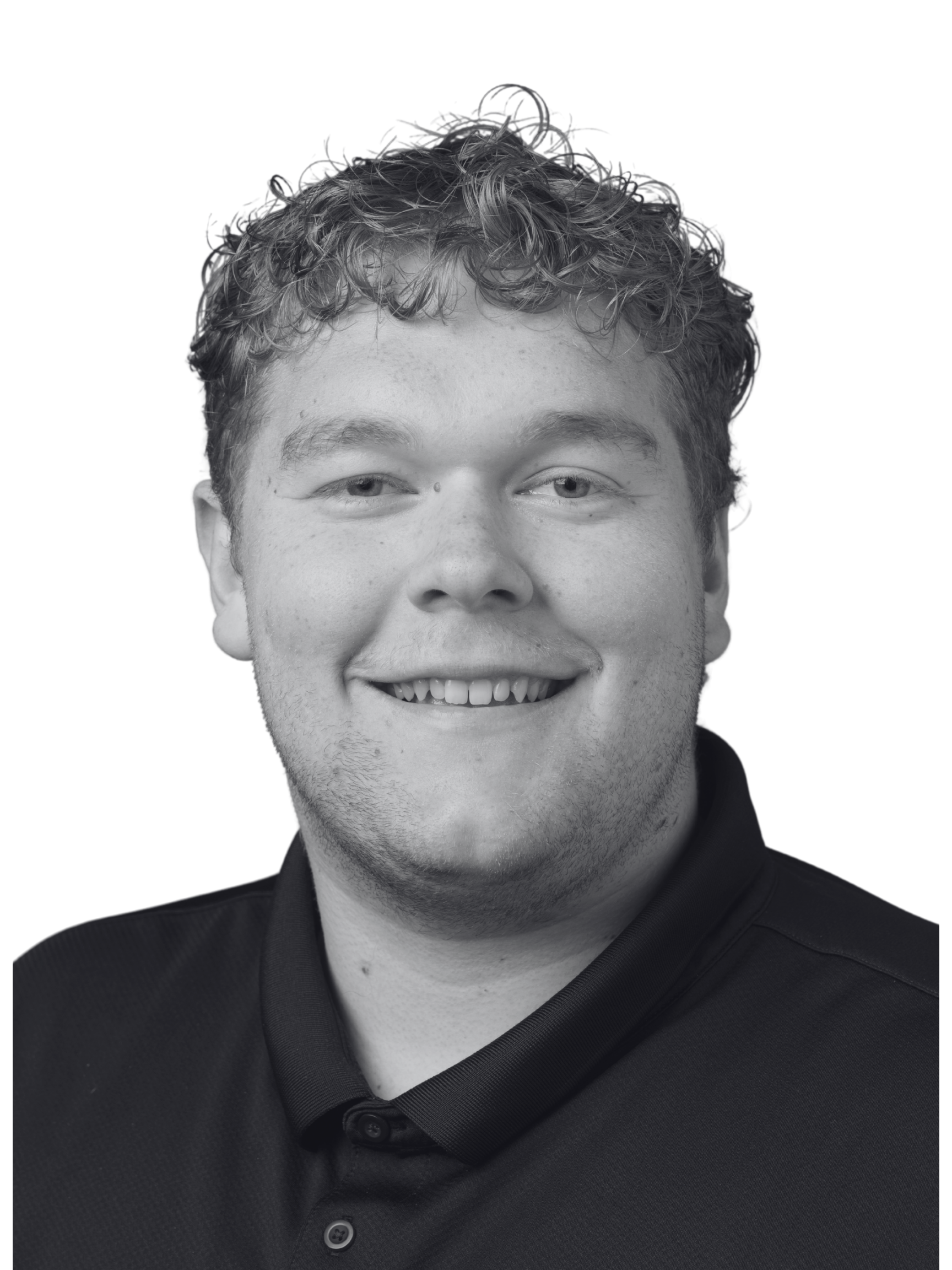 Black and white portrait of a young man with curly hair, smiling, wearing a dark collared shirt.