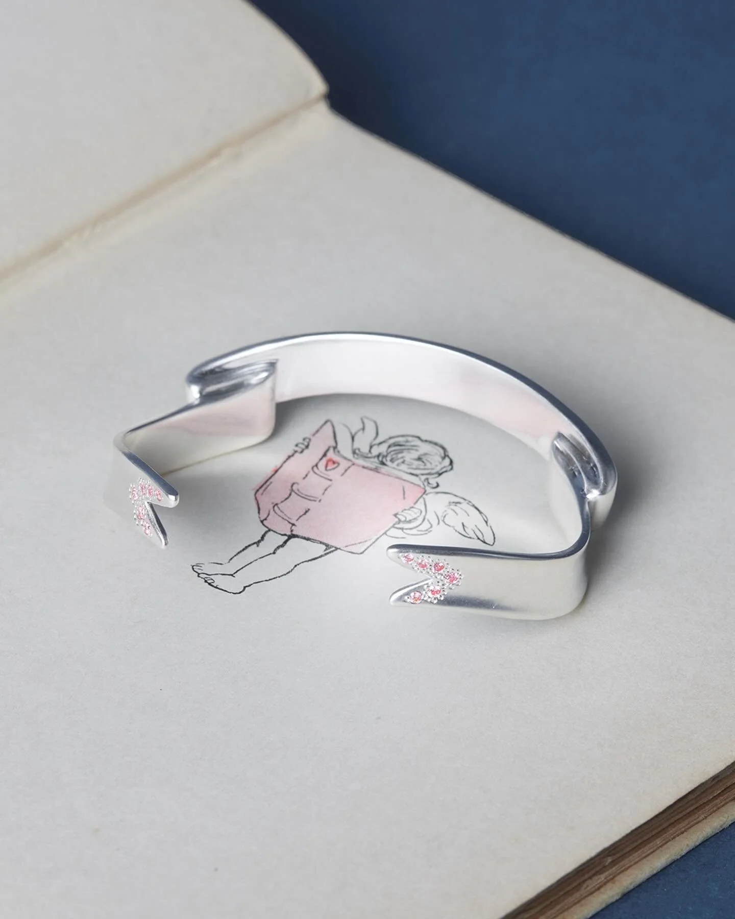 Introducing TWO new details for Cupid&rsquo;s Cuff &ndash;

1. Pink diamond accent on the ribbon ends &ndash; This will be a limited edition run of FIVE (5) pieces.
2. Custom engraving &ndash; You can now add a short message on the inner band to serv