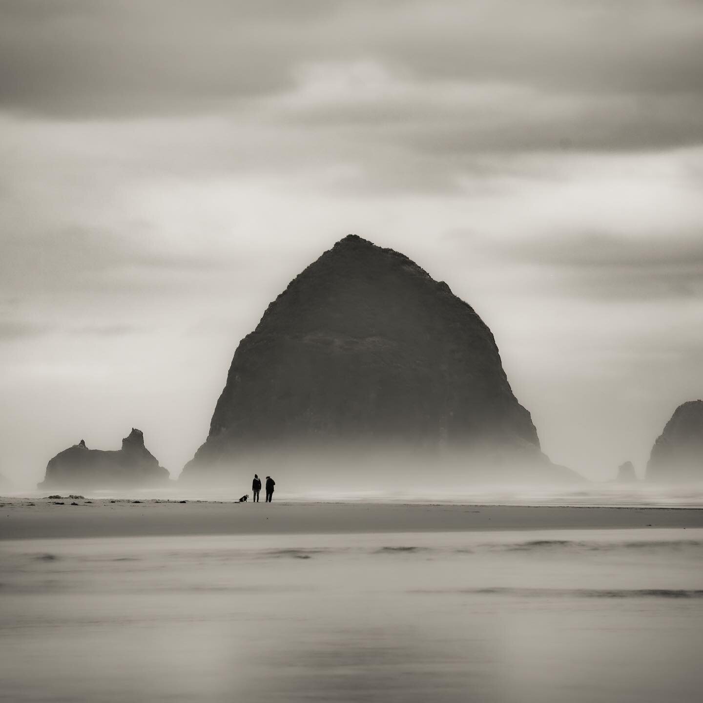 Haystack Rock is a 235 foot high monolith at Cannon Beach Oregon. I went out at sunrise and I loved how the couple and their dog were highlighted with the rising mist, which put the massive size of this geological feature in perspective. #natgeophoto