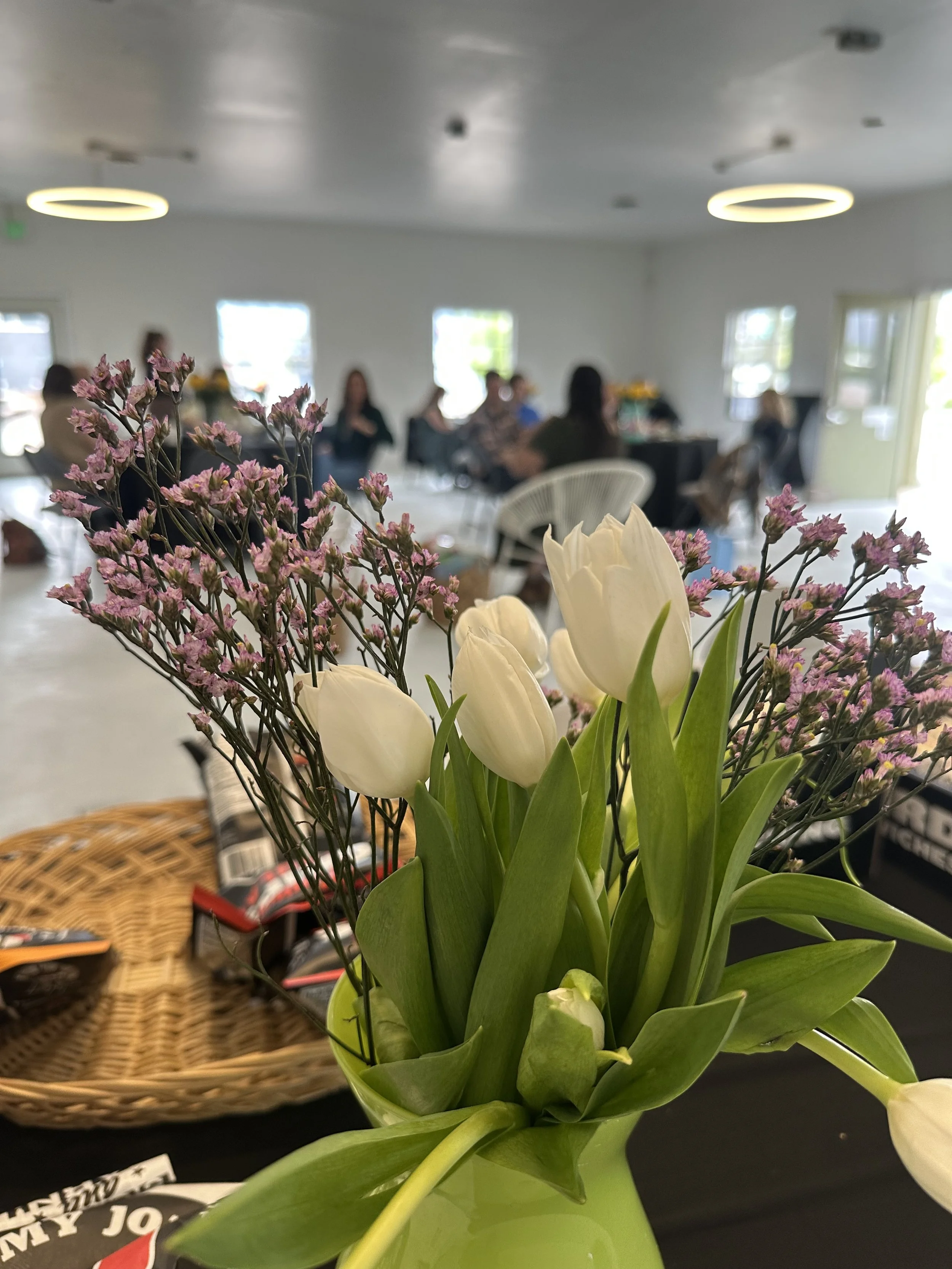 White tulip centerpiece at a seated event at Meanwhile Block
