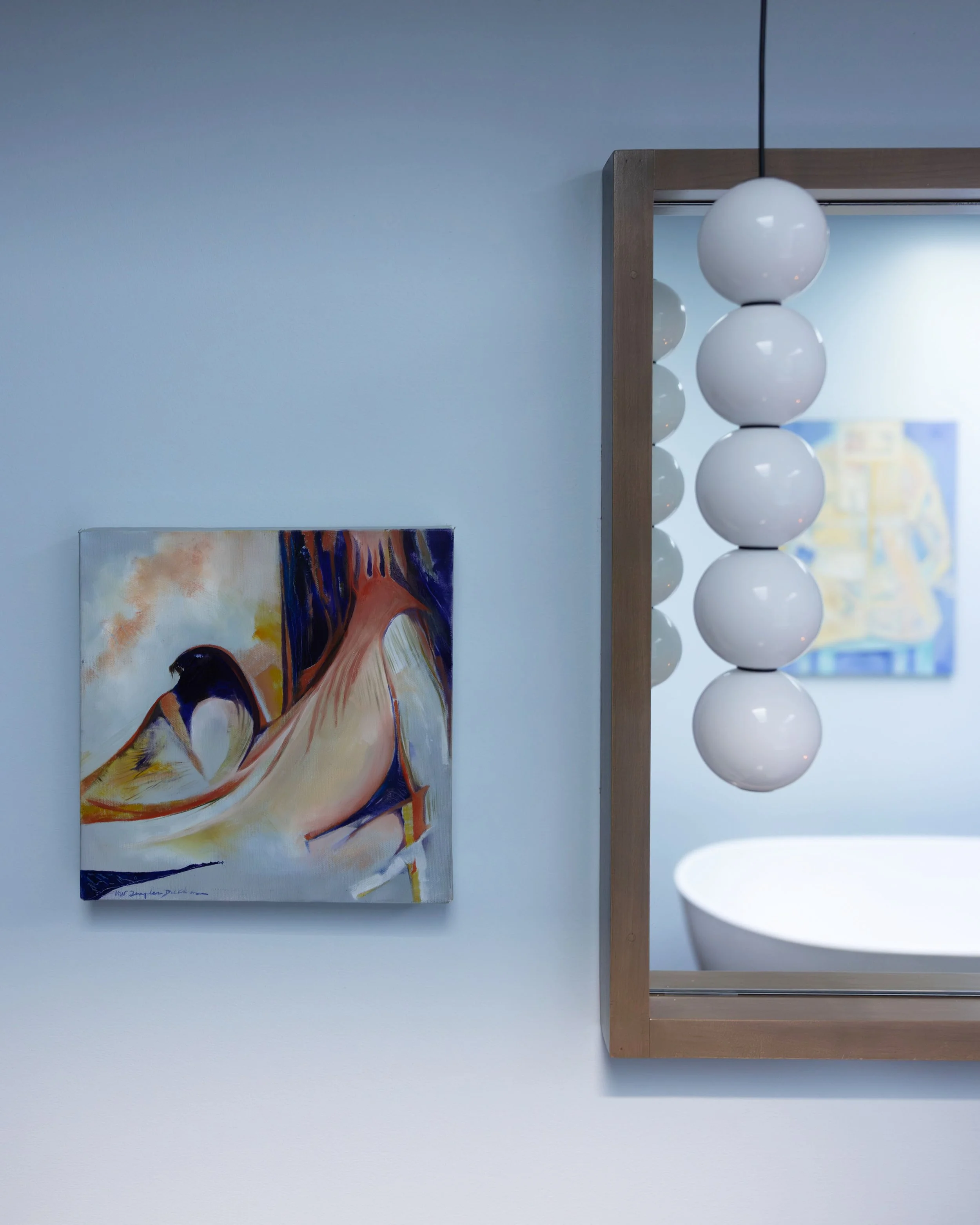 Original abstract art with stacked globe pendant light and custom vanity mirror.
