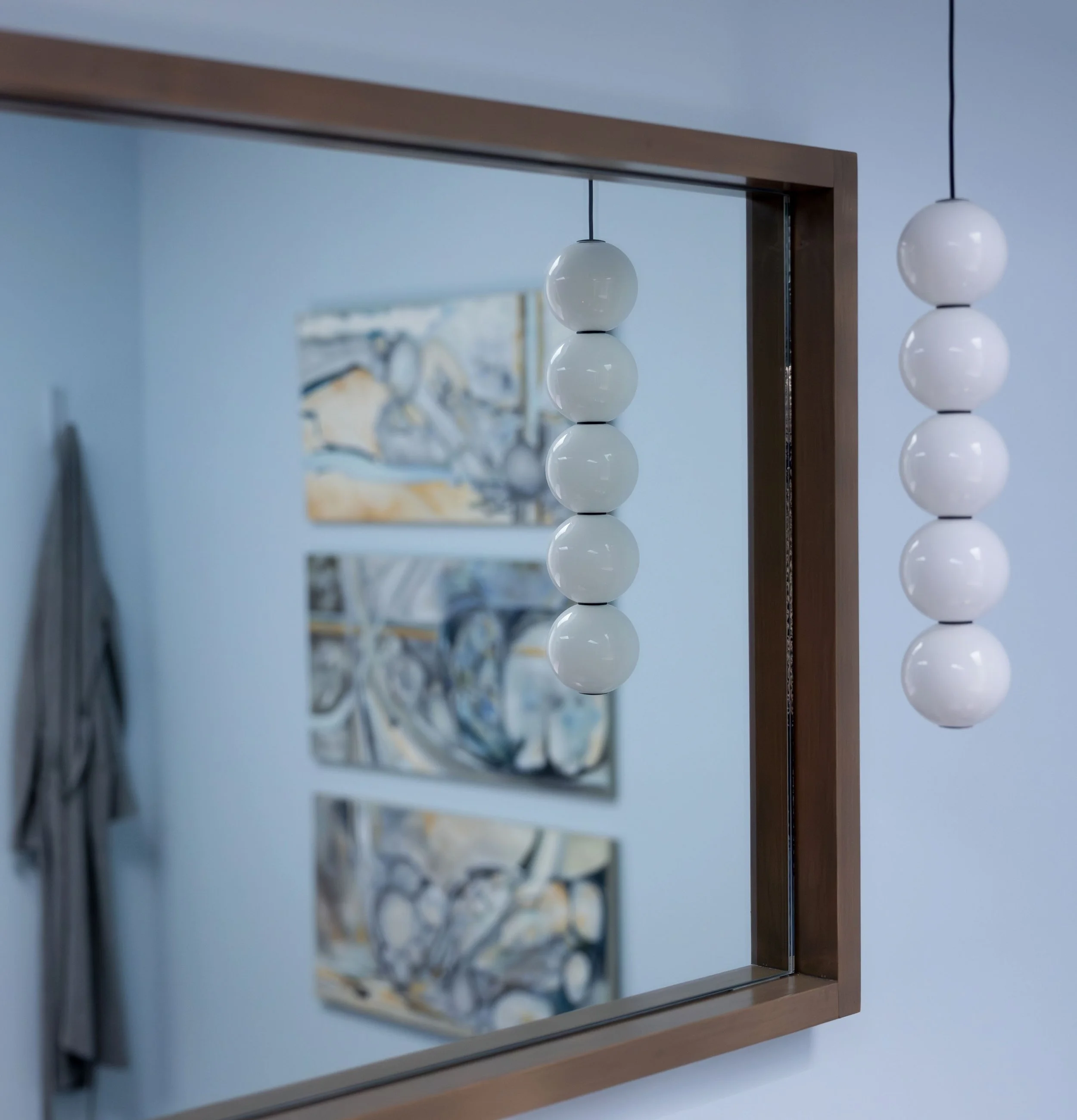 Custom vanity mirror with stacked globe pendant light.