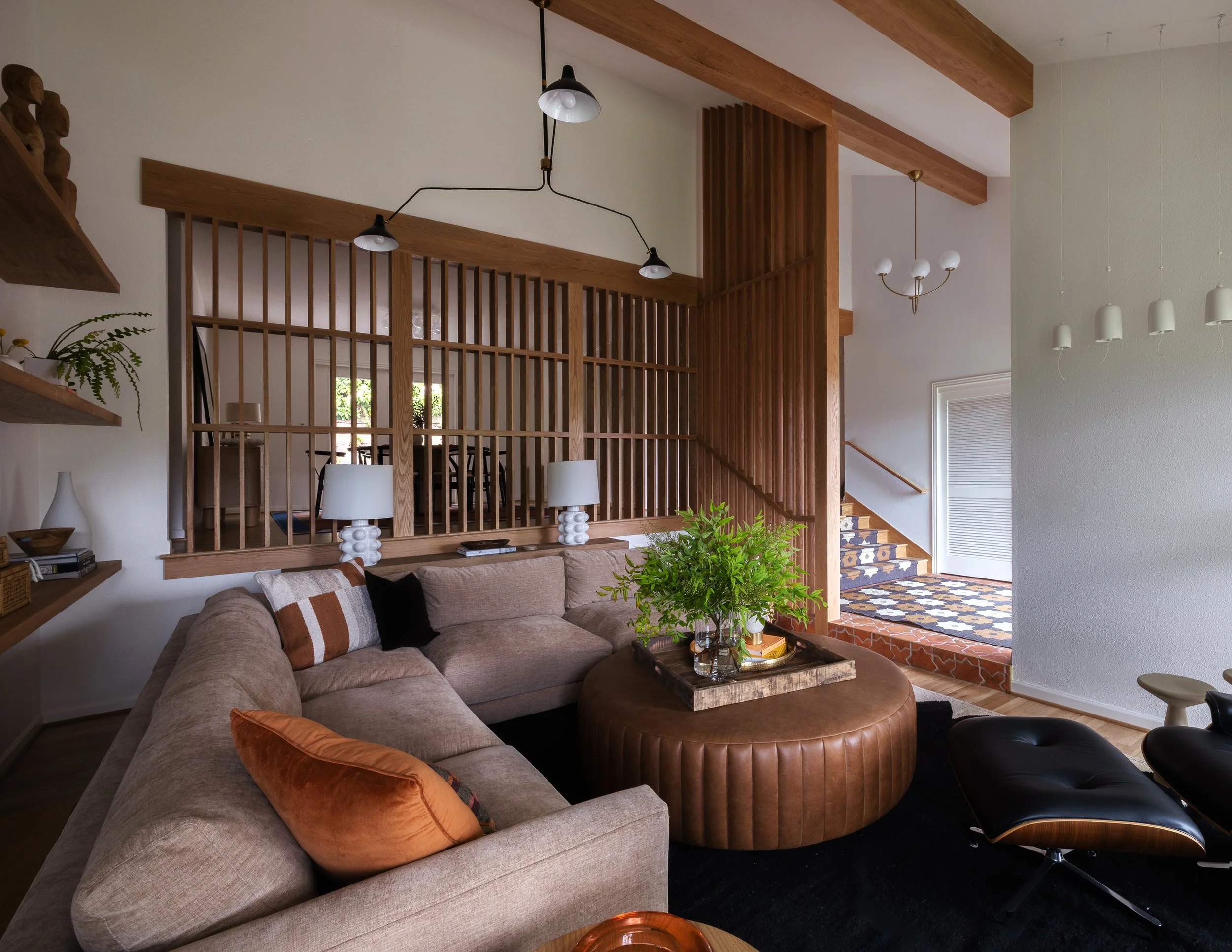 Living room with high vaulted ceilings, slat wall, and a sectional couch.