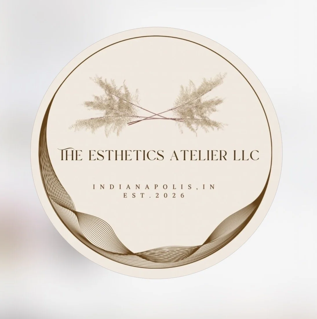 Logo for The Esthetics Atelier LLC, featuring two crossed feathers, with the text, 'Indianapolis, IN, EST. 2026,' on a circular, elegant background.