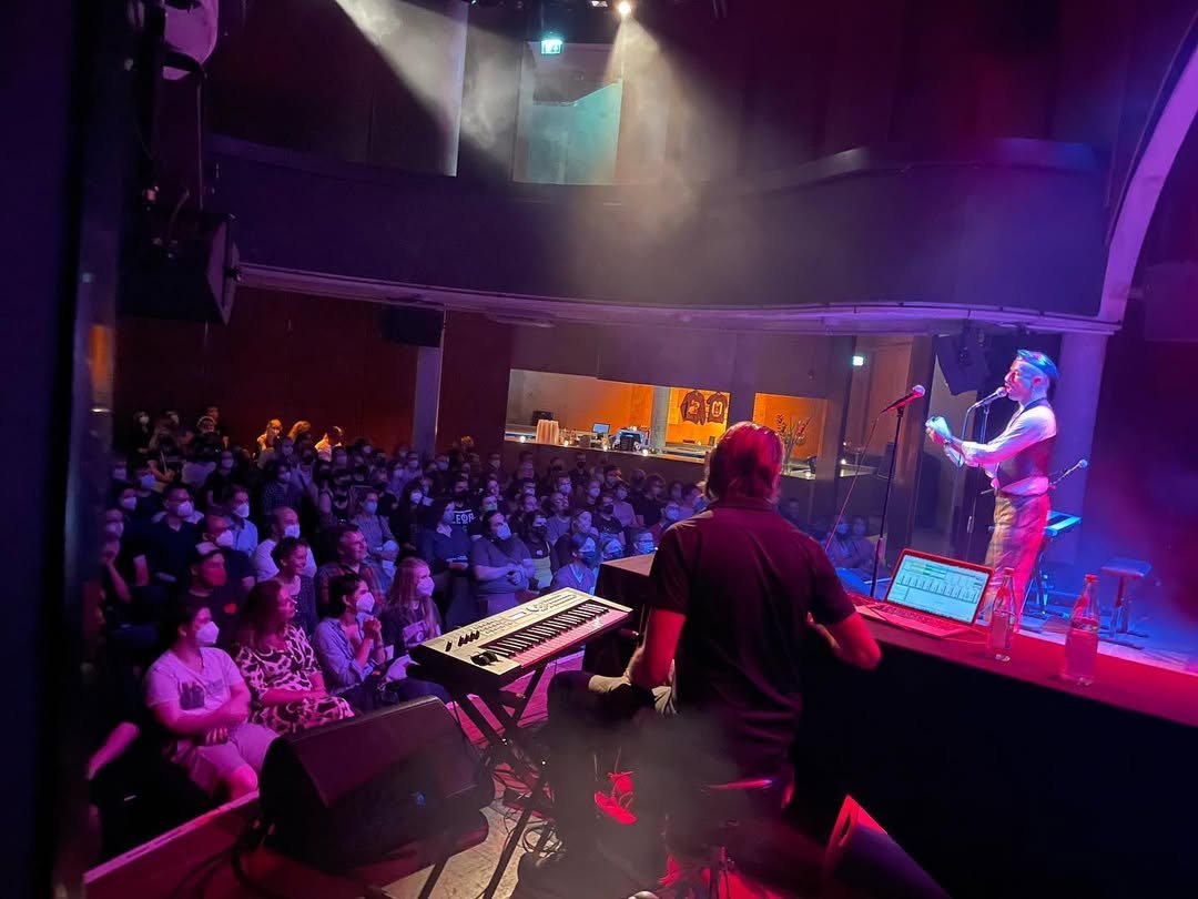 Disparition performing on keyboard onstage during a live Welcome to Night Vale show in Berlin, 2023.