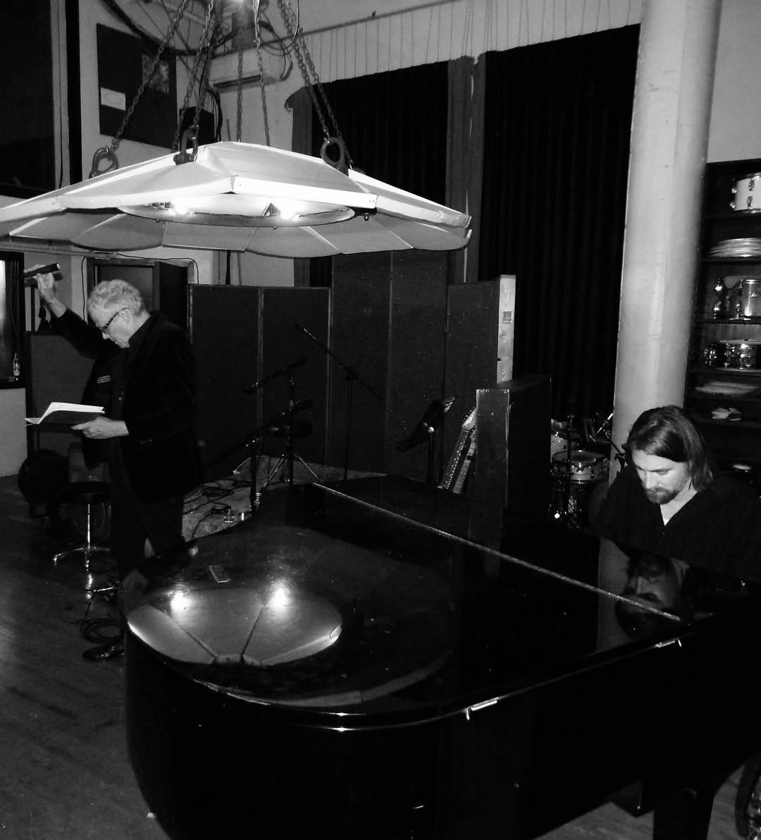 Disparition performing on piano with David J reading poetry during a performance at the Agape Lodge Poetry Society, 2024.