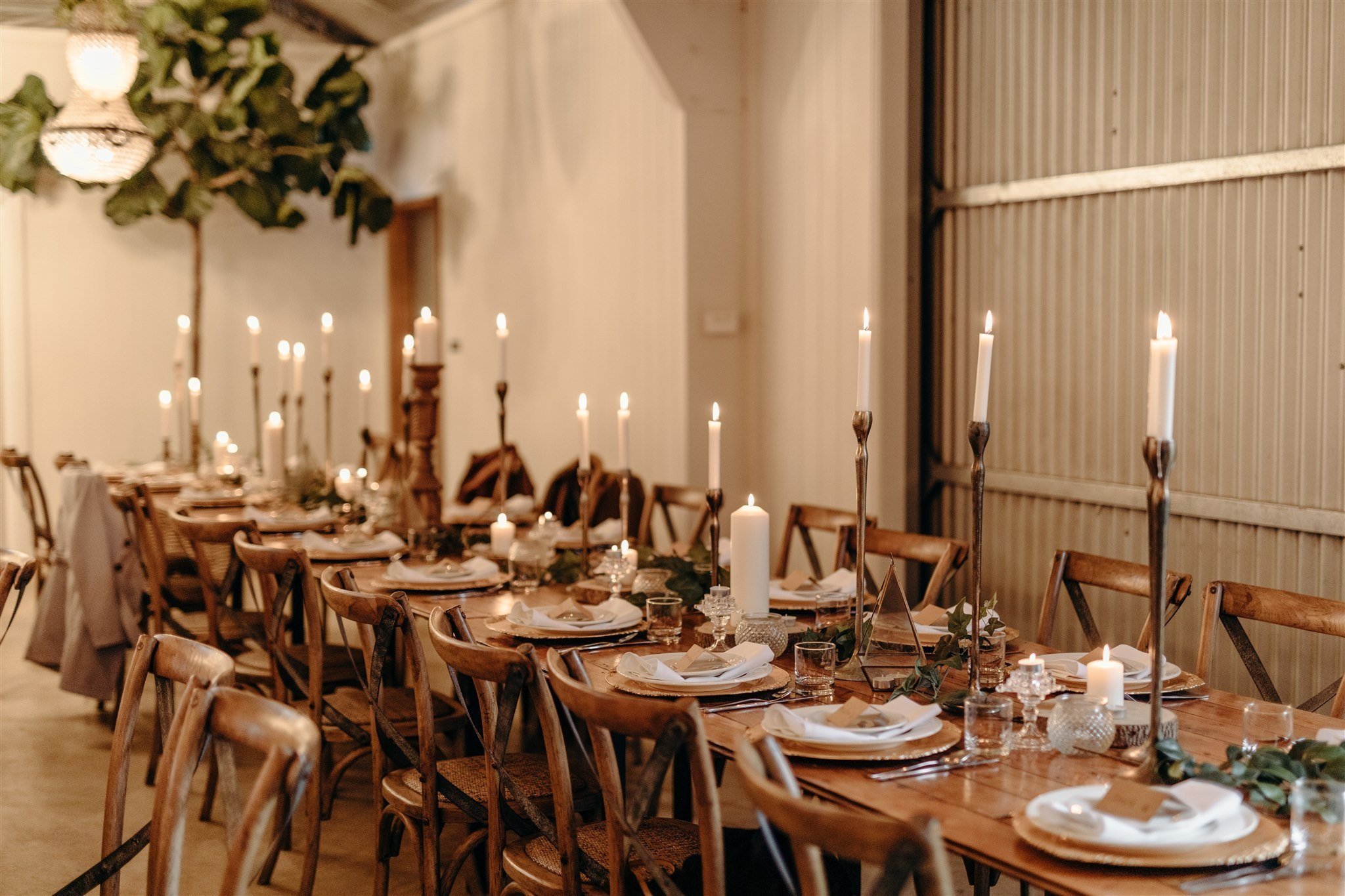 Wedding table setting in a barn with candles. Photo by Samantha Riles