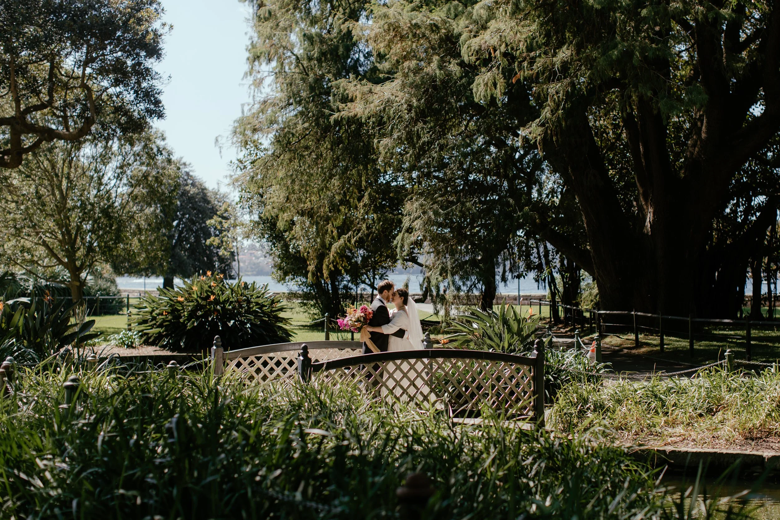 Married couple embracing on a bridge. Photograph by Samantha Heather Photography