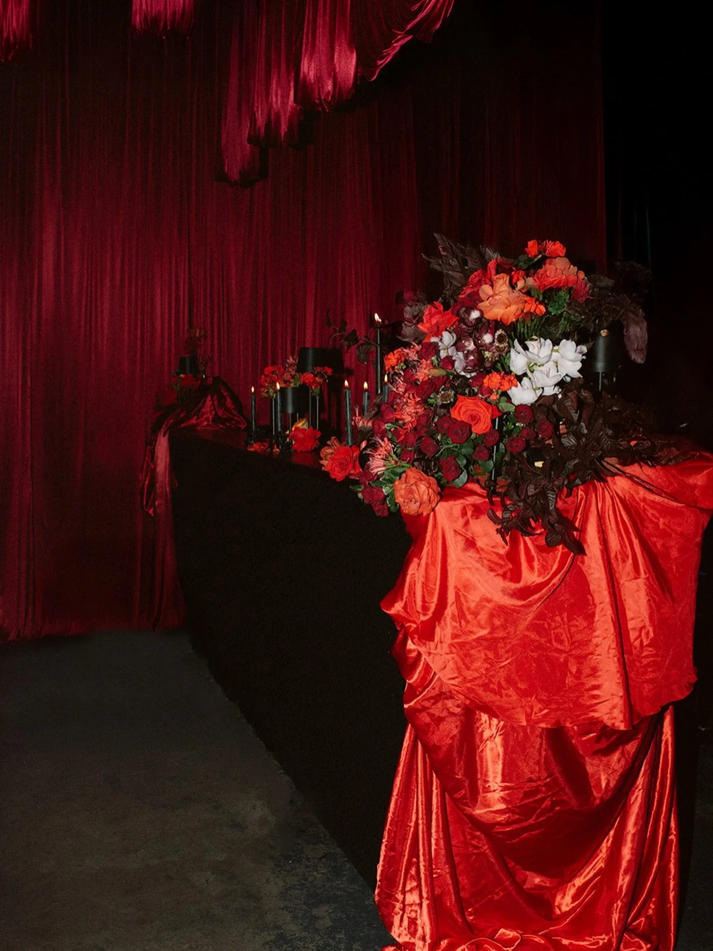 Soft lighting and polite d&eacute;cor?
That&rsquo;s not our style.

A wedding should have the right kinda tension. Mood. A little danger in the air. ❤️&zwj;🔥

Think blood-red drapes pooling onto the floor.
Towering florals spilling across silk.
Cand