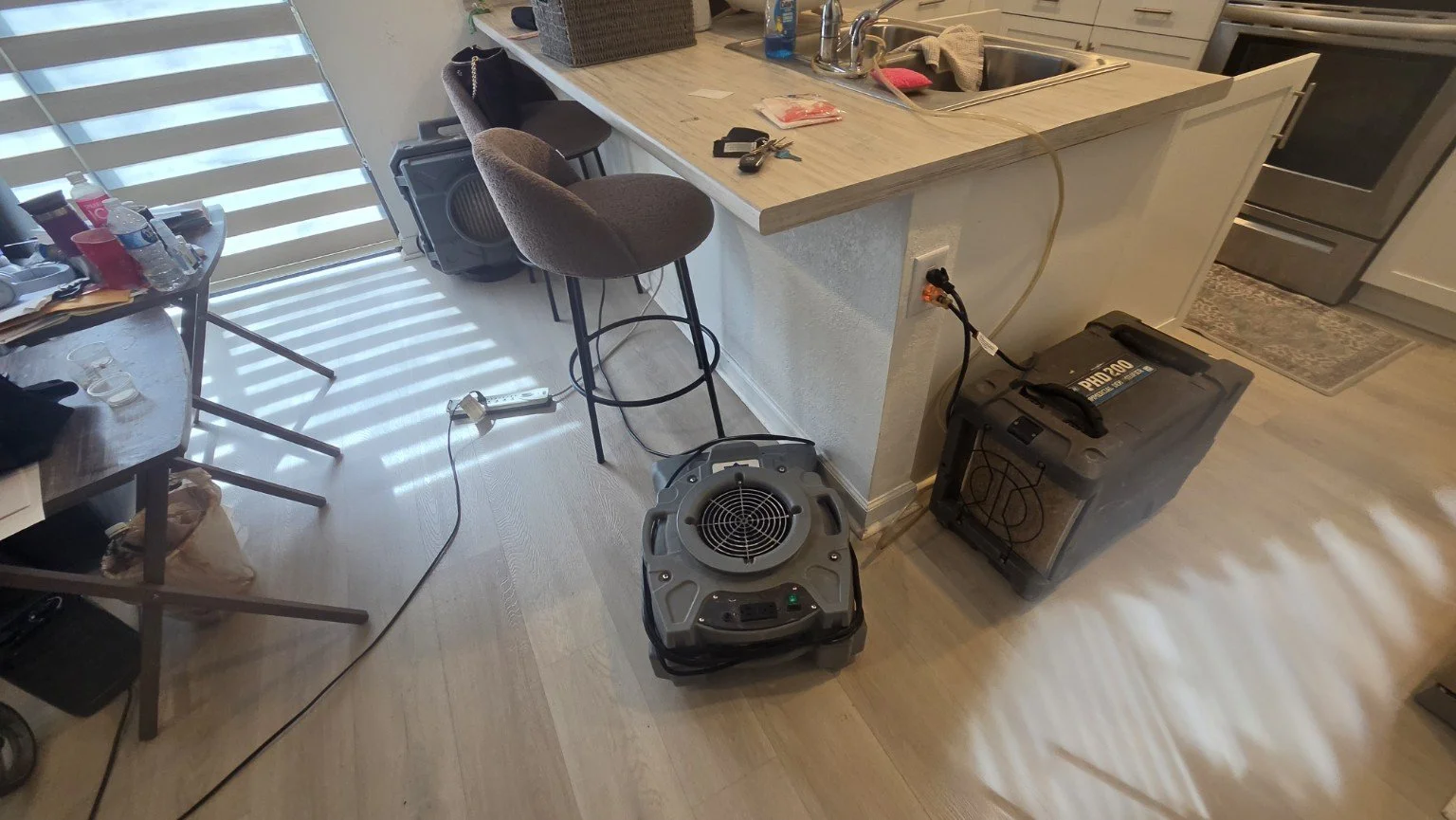 Drying equipment positioned around the kitchen island after the leak was stopped.