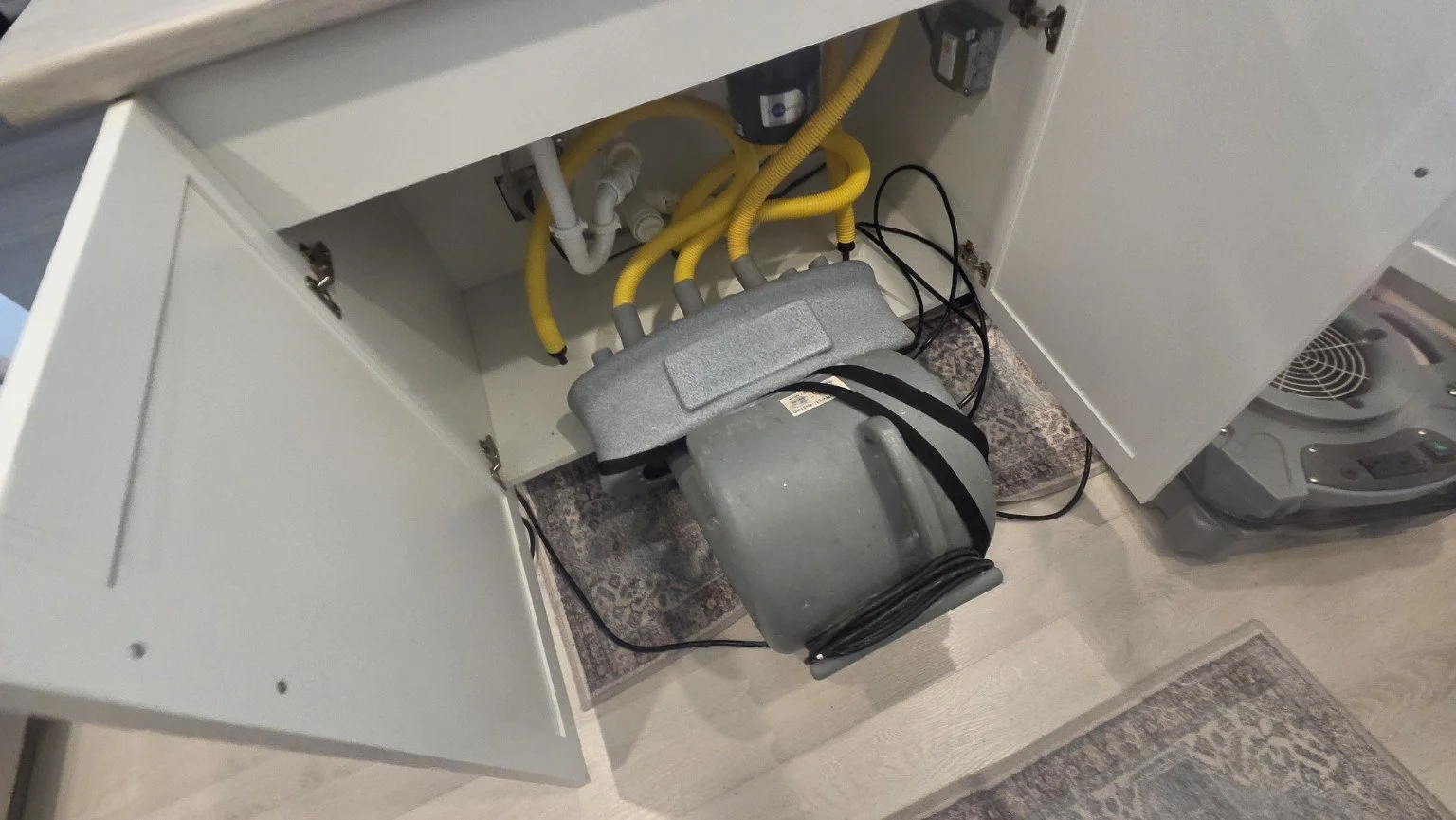 Targeted cabinet drying after the leaking garbage disposal was replaced and tested for leaks.