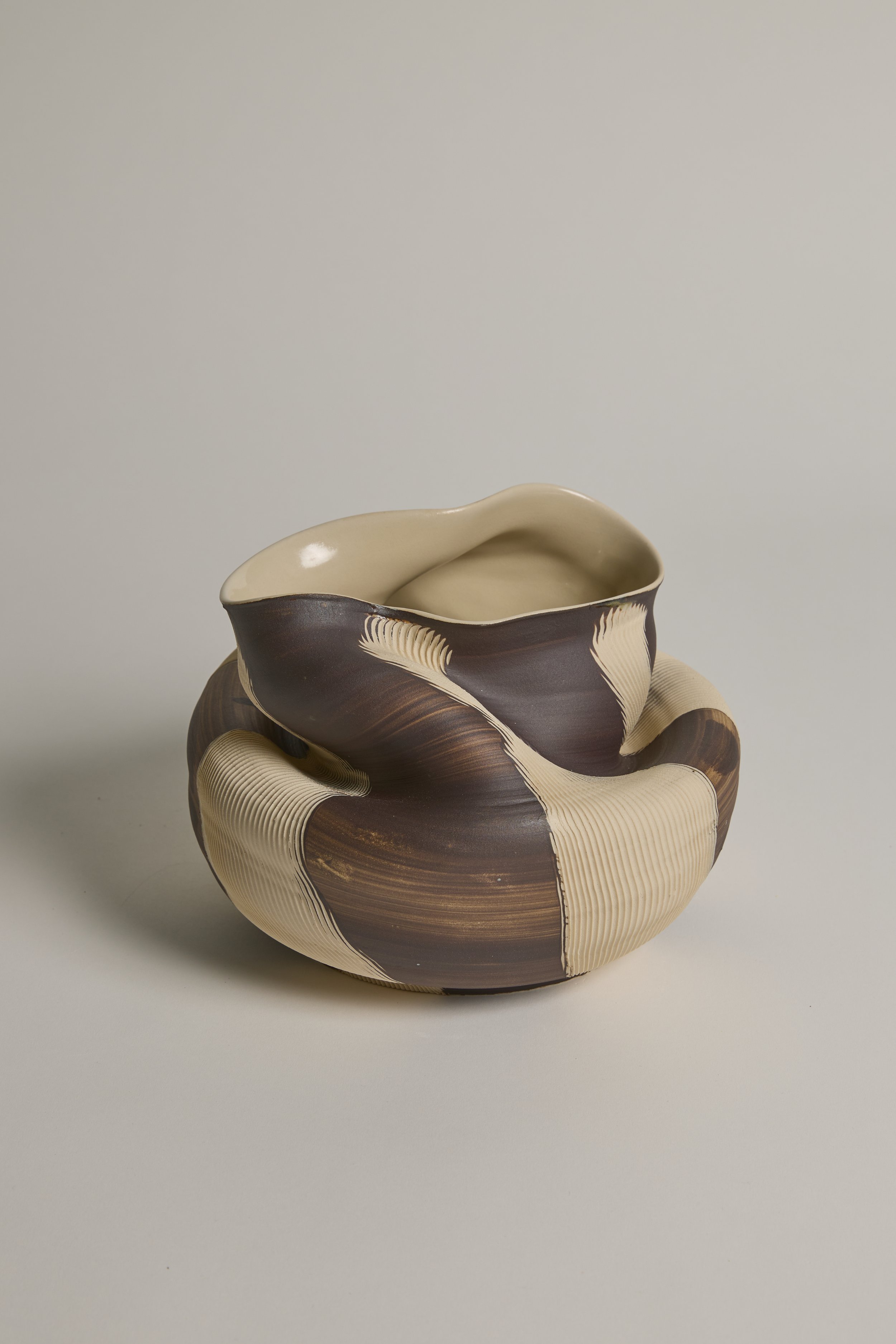 Sculptural ceramic vessel by Melbourne ceramic artist Alyssa Nuttall, featuring an asymmetrical organic form with carved, layered surfaces.