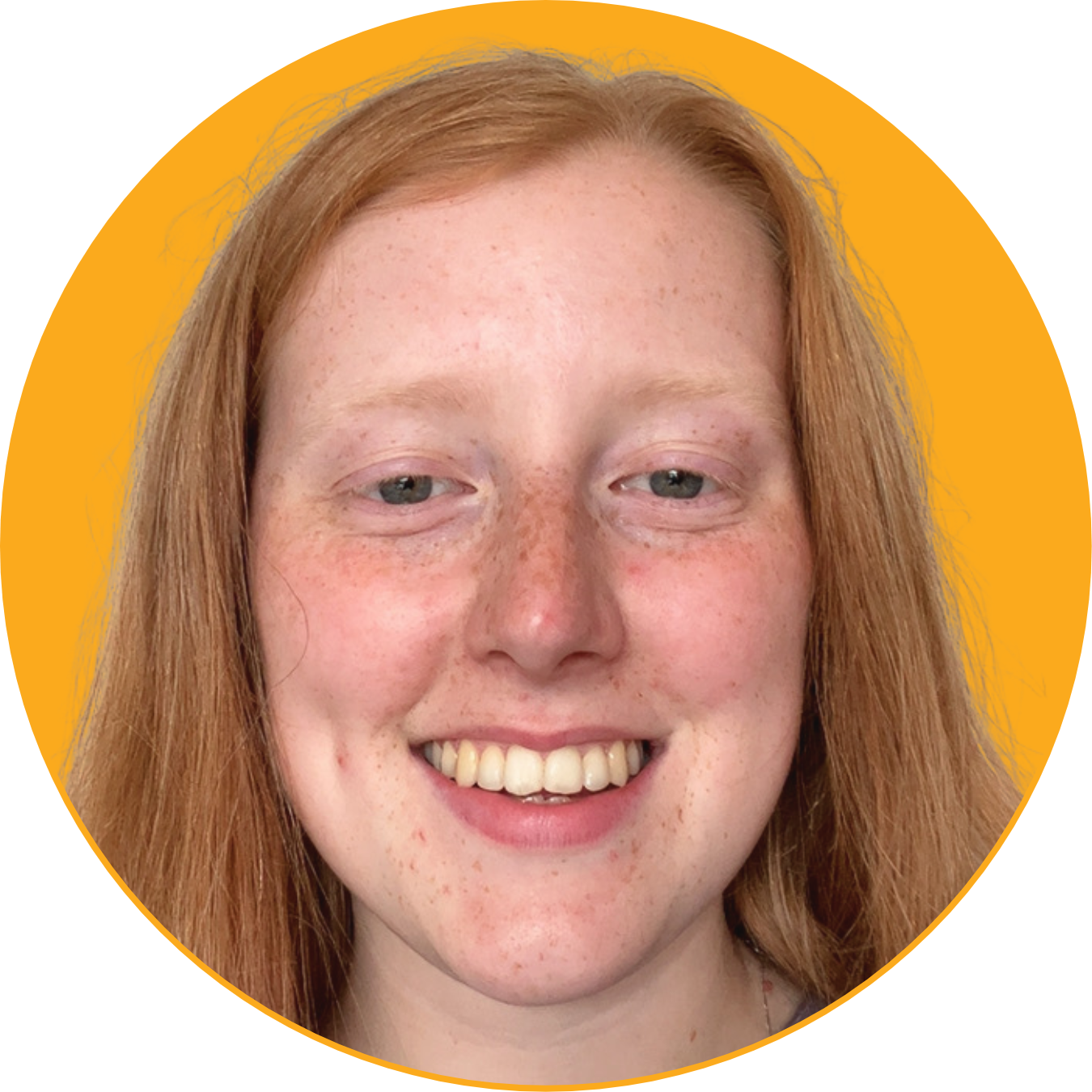 Close-up of a smiling young woman with red hair, freckles, and light-colored eyes against a yellow background.