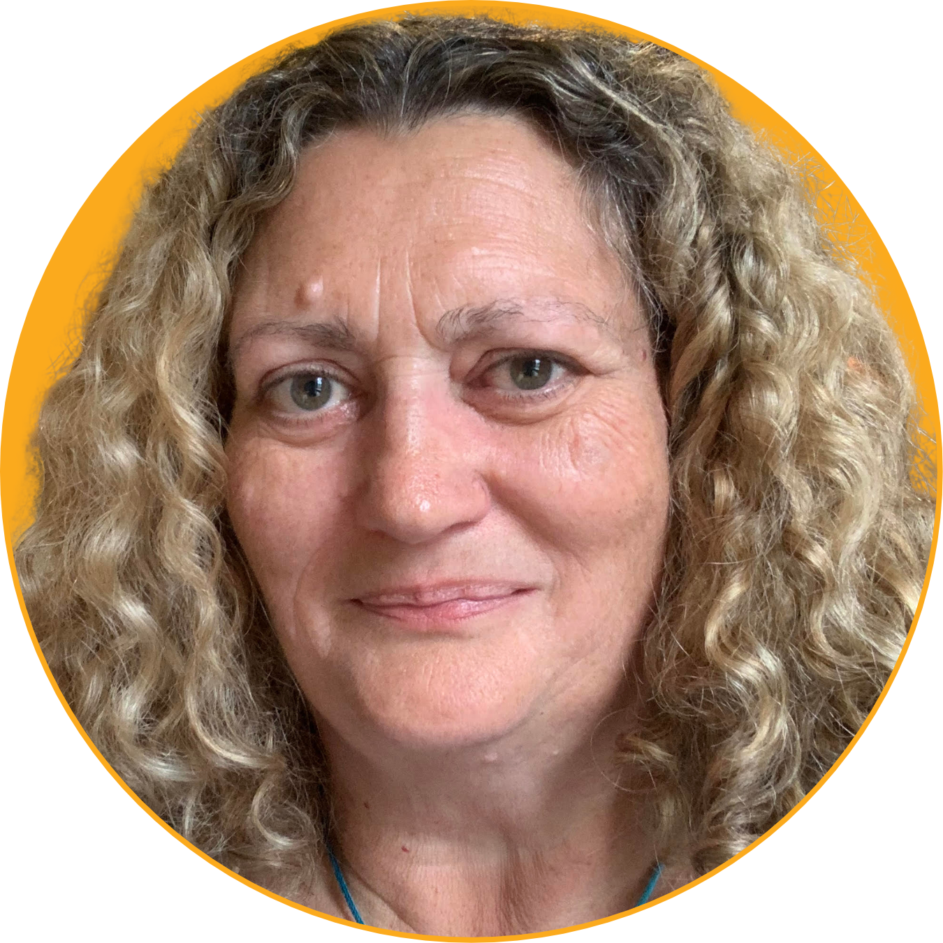 Close-up of a woman with long, curly blonde hair and blue eyes, smiling slightly, with a yellow circle background.