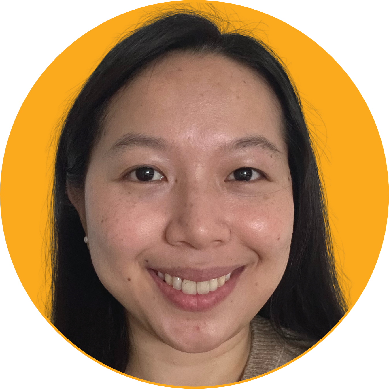 Close-up of smiling woman with dark hair and light skin, wearing a beige top, against an orange background.
