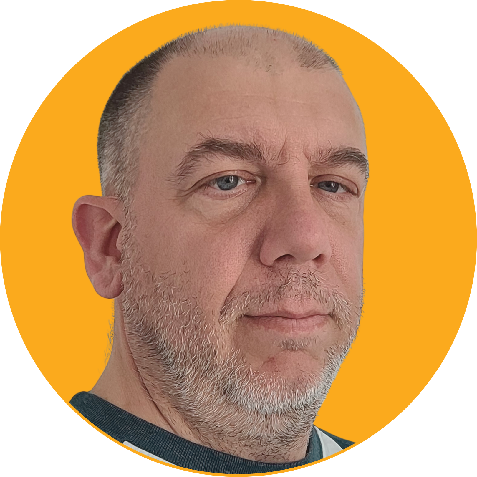Close-up of a middle-aged man with blue eyes, short gray hair, and a gray beard, looking directly at the camera with a neutral expression, against a yellow circular background.