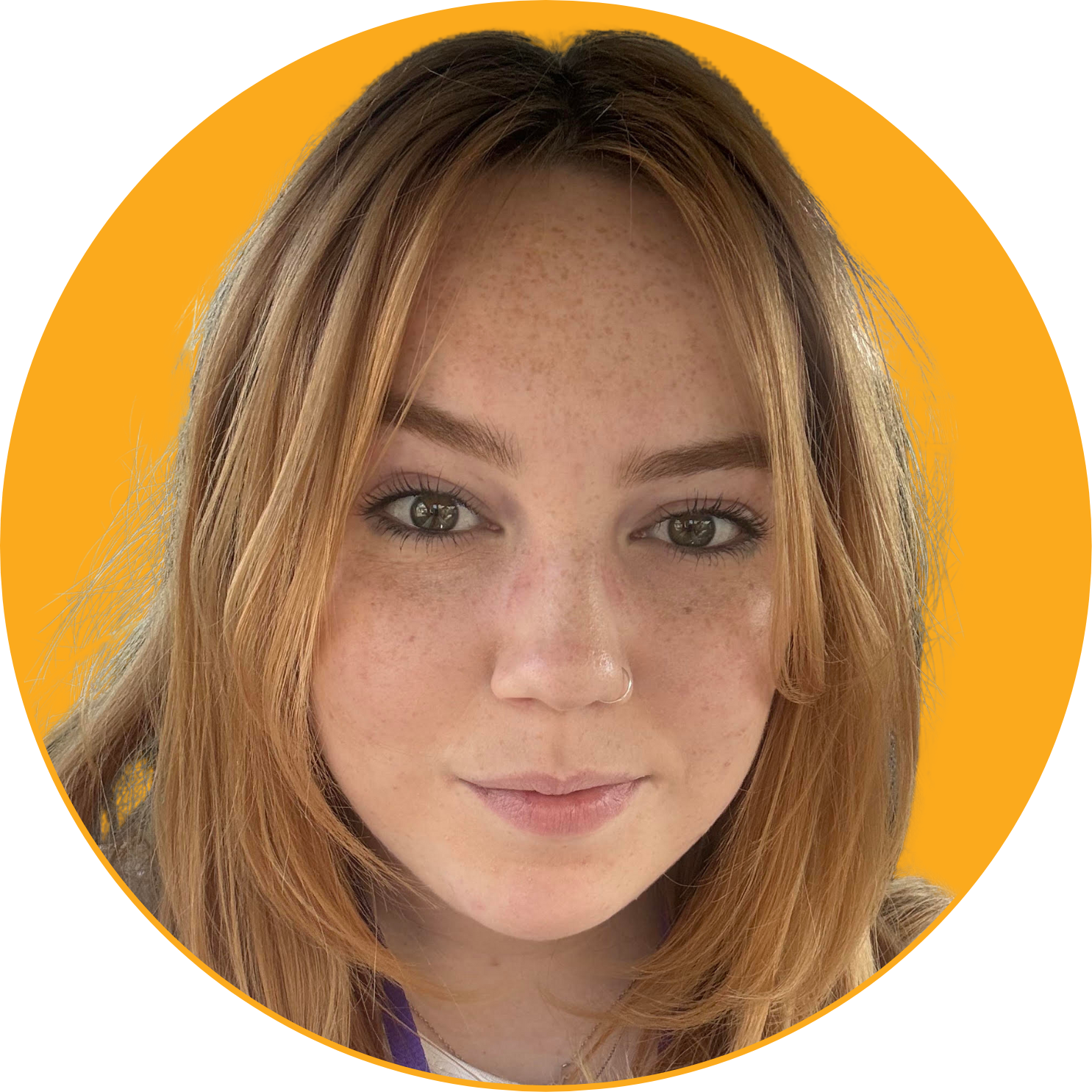 Close-up portrait of a young woman with red hair, freckles, green eyes against a yellow background.