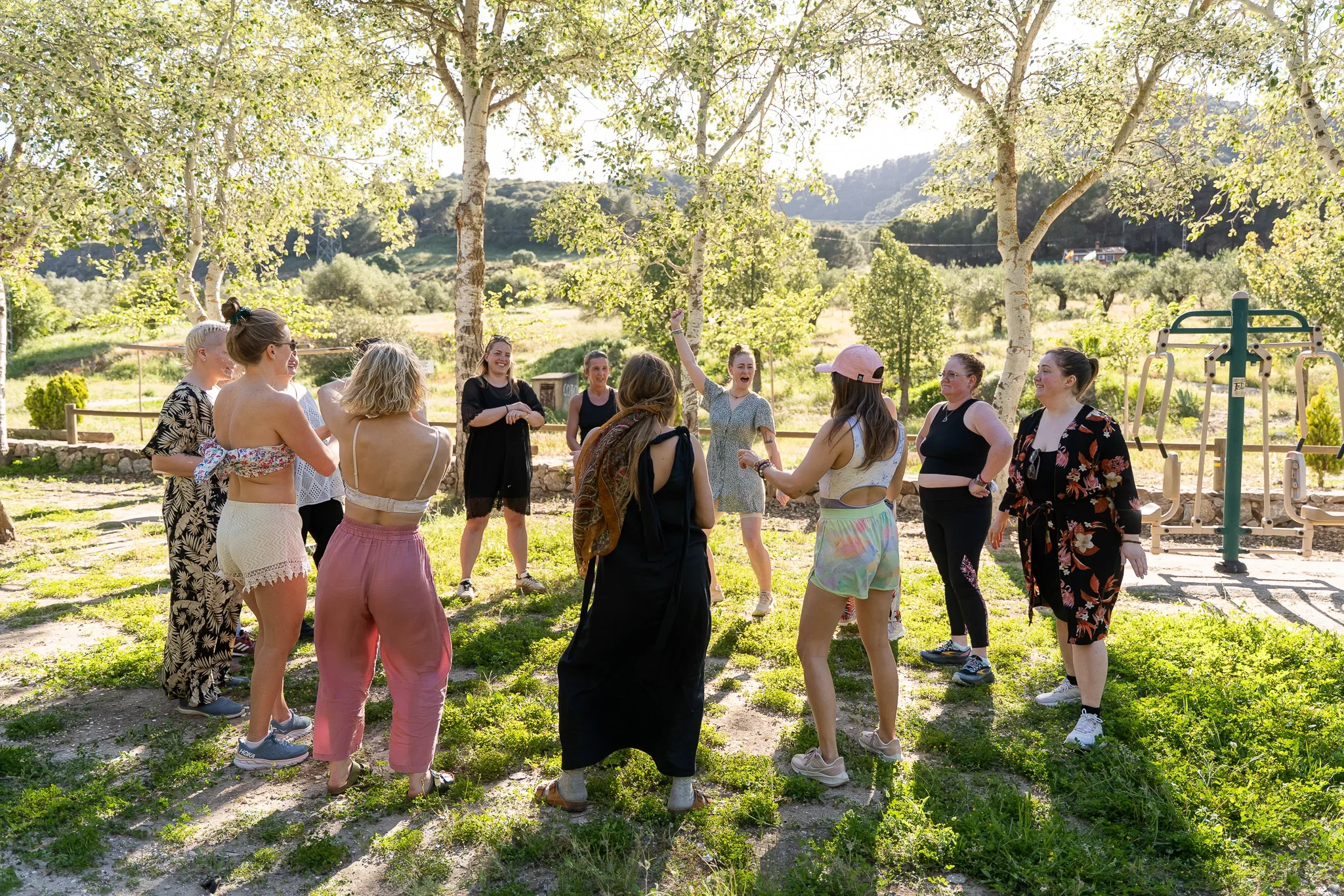 Kvinner står i ring under et Yogaretreat en sommerdag