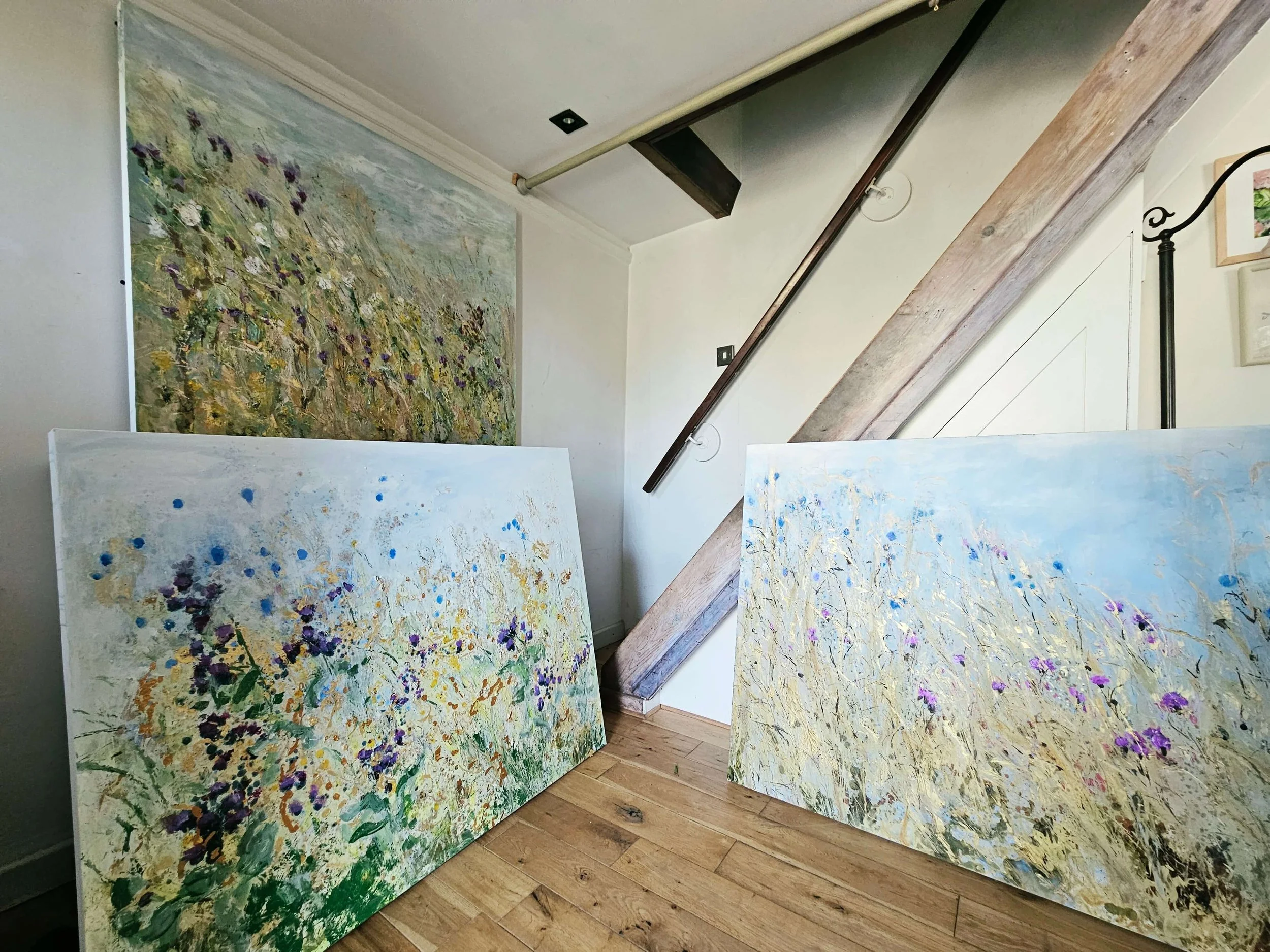Three contemporary meadow paintings showing different moments of the summer season in Sally Stafford's studio.