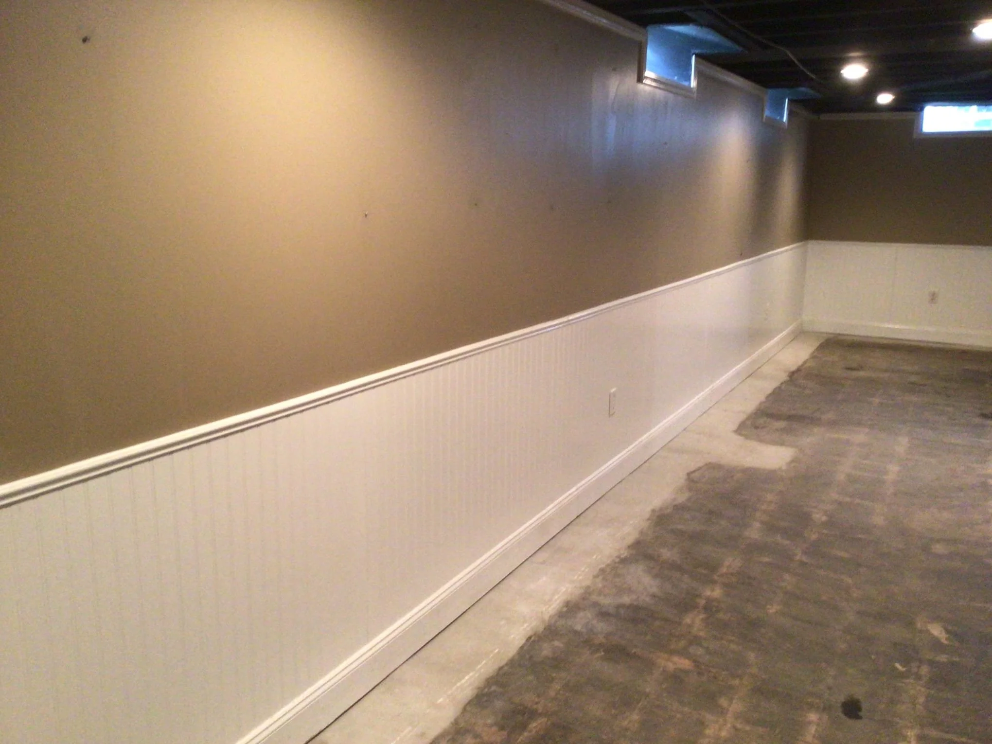 Finished basement in Sterling Heights, Michigan after interior waterproofing installation and wall restoration to prevent water damage.