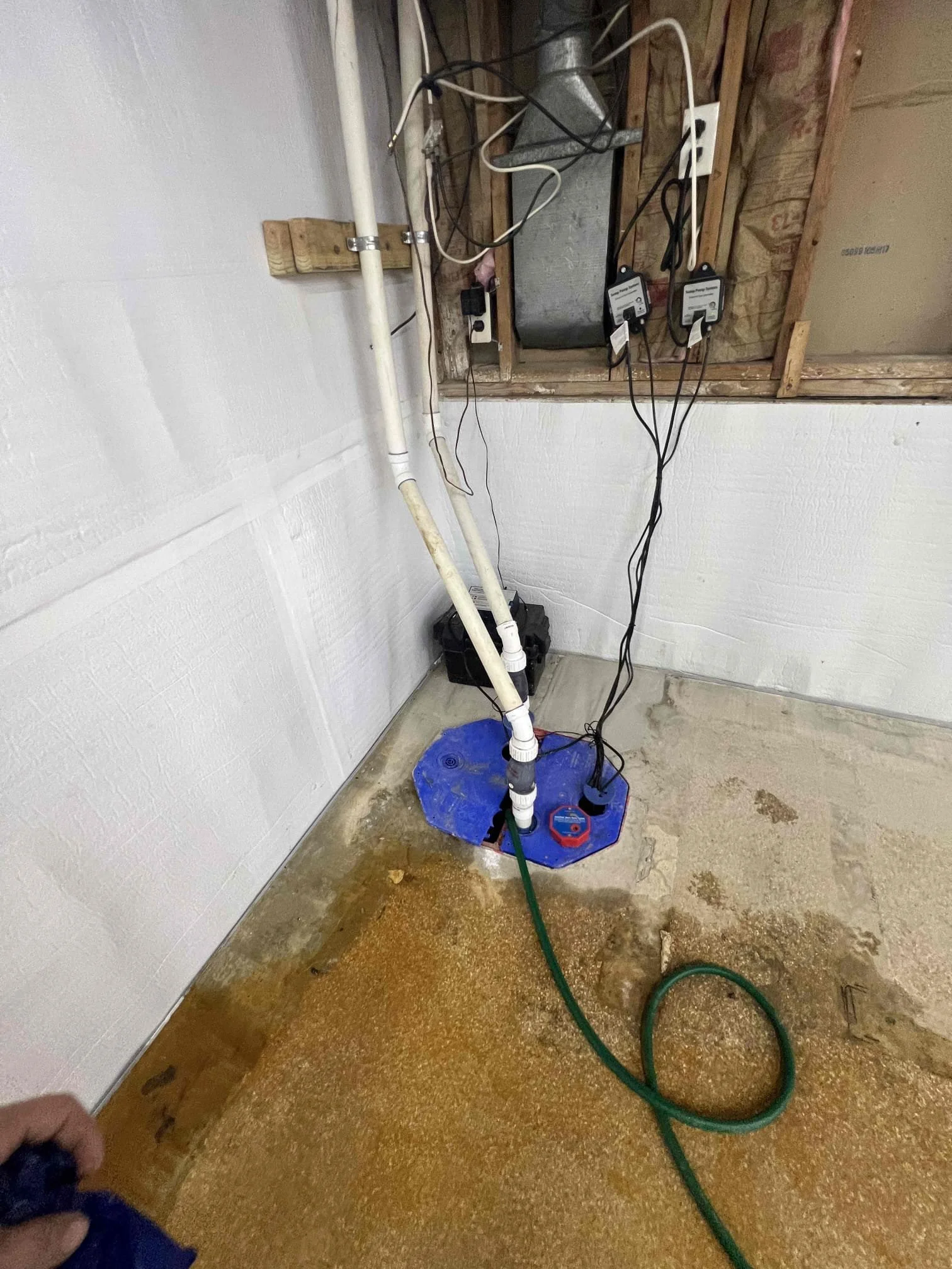 Basement in Fraser, Michigan showing water intrusion and standing water along the foundation before waterproofing installation.