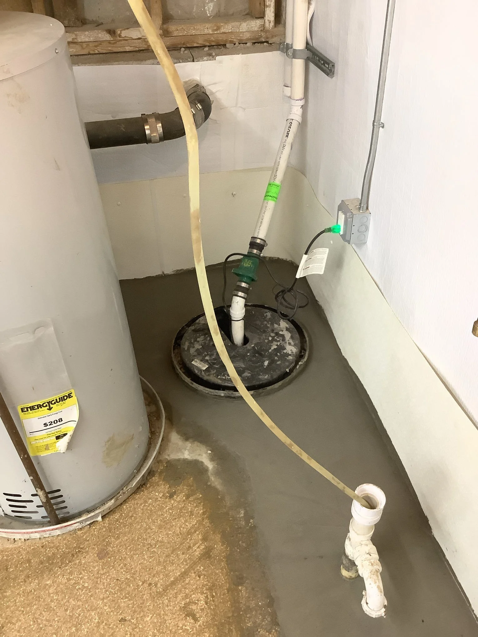 Completed basement waterproofing system in Fraser, Michigan with drain tile, sump pump, and vapor barrier installed.